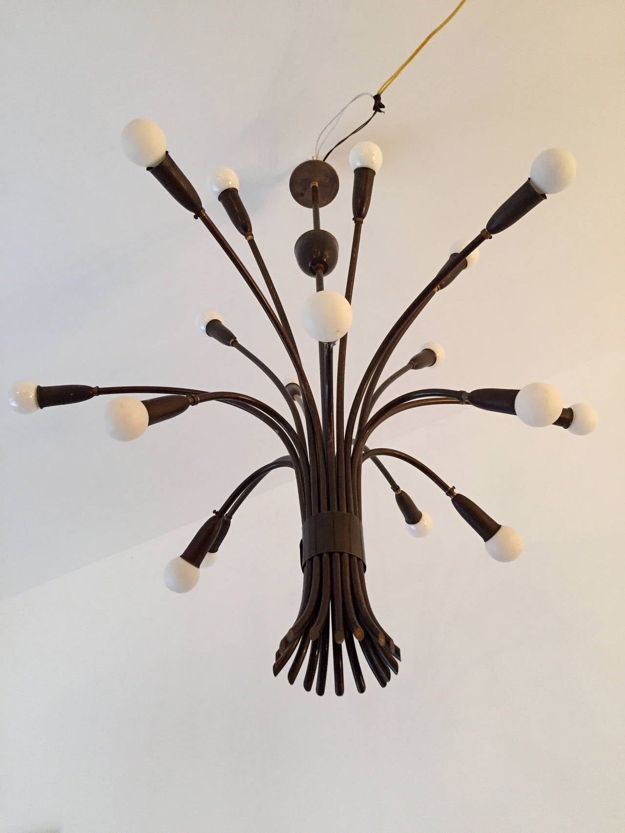 A beautiful 1940s darkened aged brass eighteen-light chandelier by the famed Italian lighting maker, Lumi. Rewired.