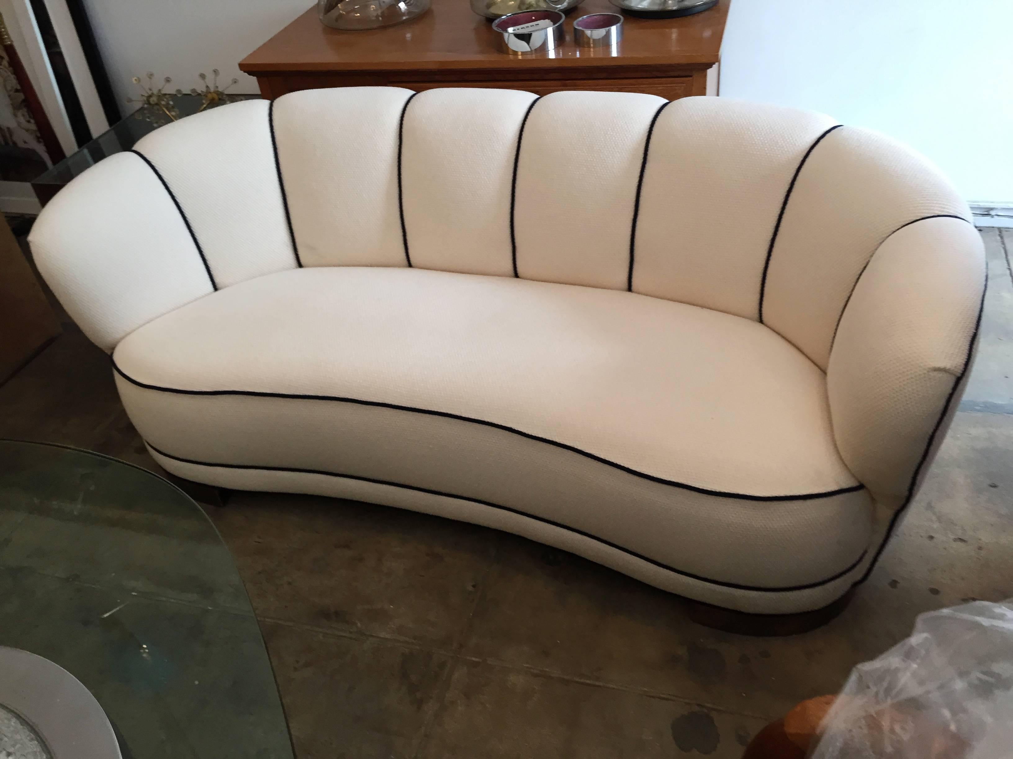 A wonderful original 1930s Swedish Art Deco curved sofa reupholstered in a light cream wool with navy piping for a nautical look.