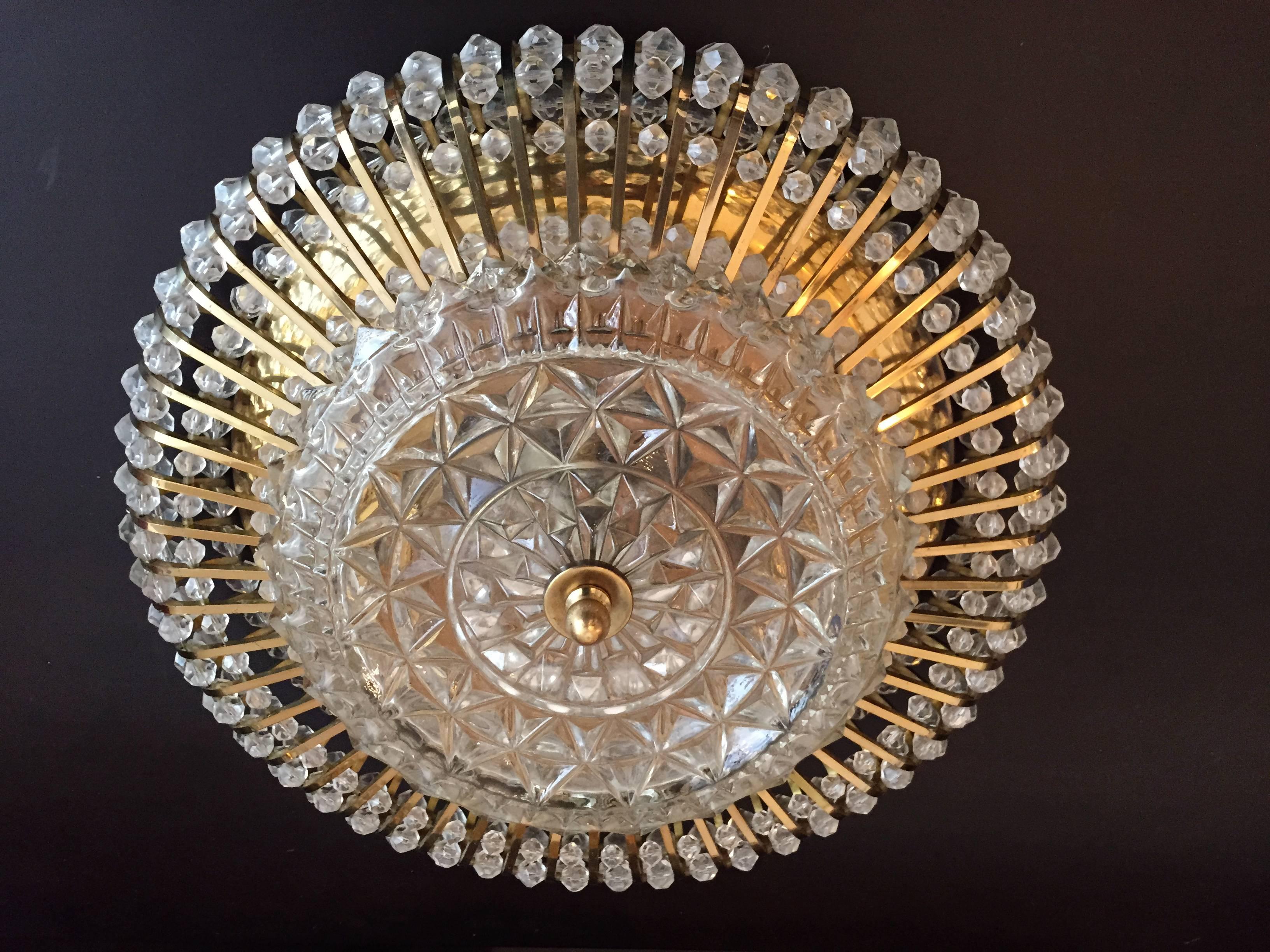 A great pair of 1950s Austrian flush ceiling lights composed of a golden brass fixtures and decorative crystal sand a cut-glass center shade. Three light sources each. Rewired.