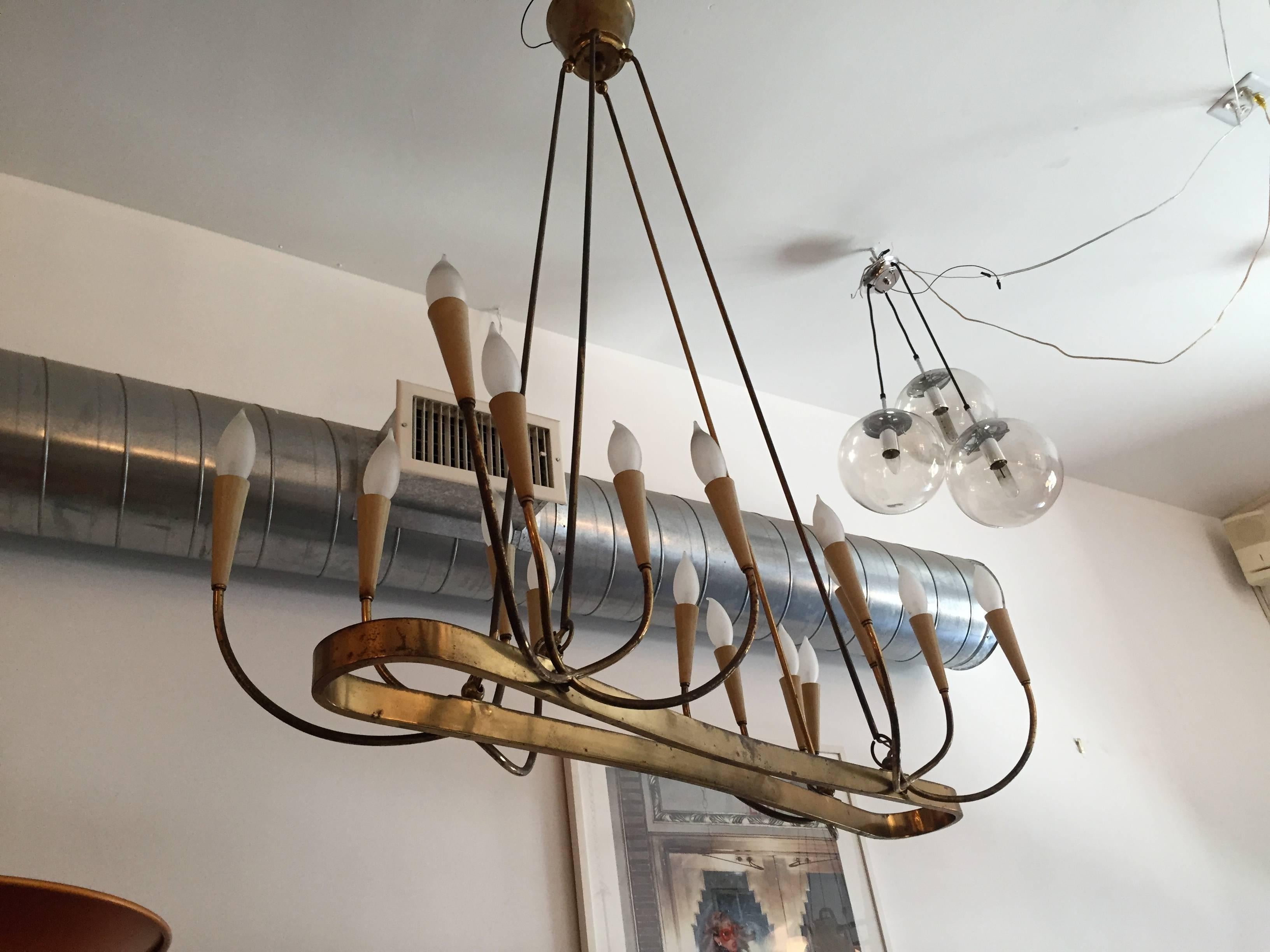 A wonderful large 1940s Italian aged brass and cream enamel 16 light chandelier. Rewired.