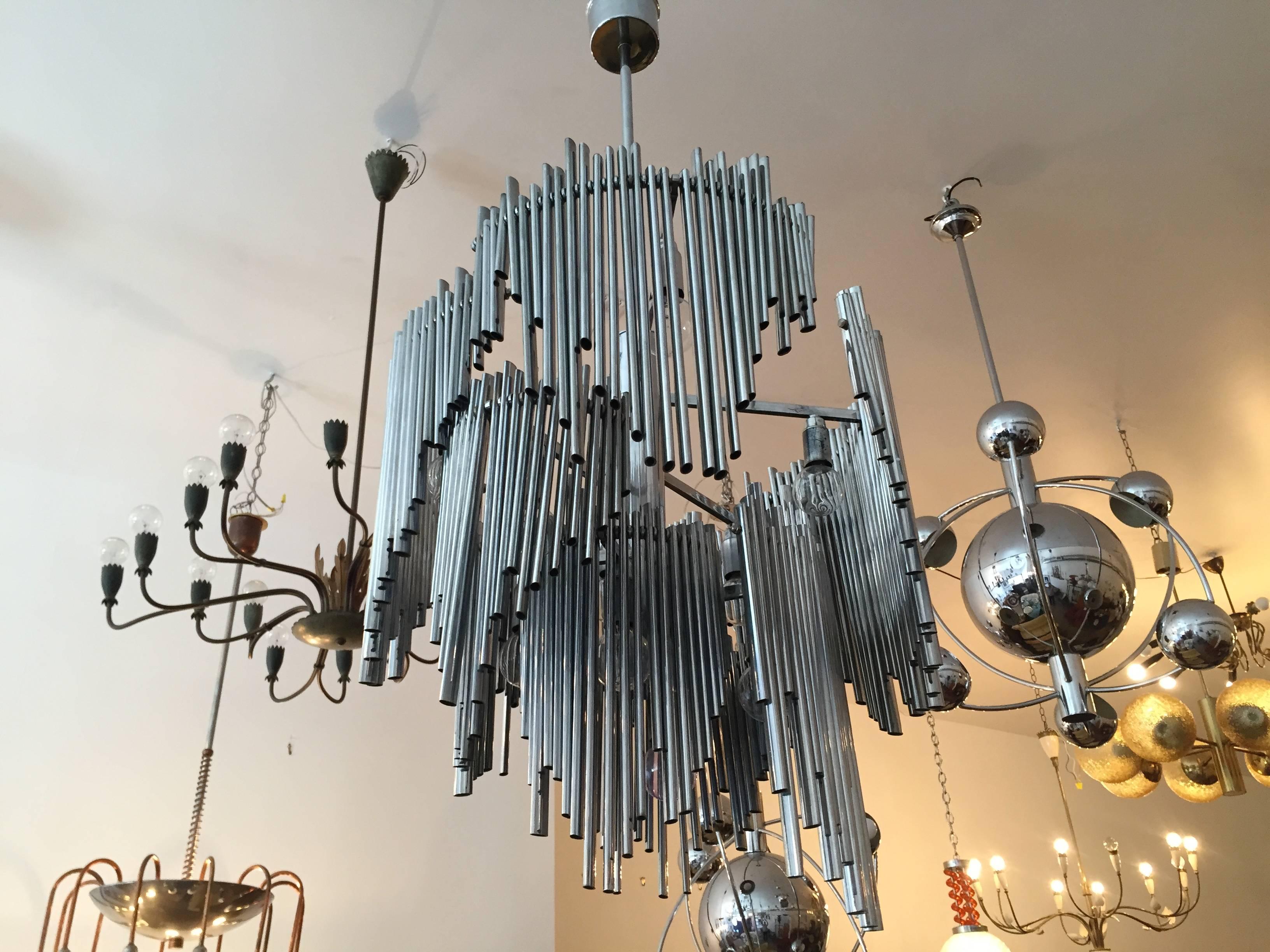 A 1970s high style Italian sculptural chrome chandelier. The chandelier has ten lights sources and is composed of steel pipes in varying length which freely swing on the chrome frame. Rewired. Rare.