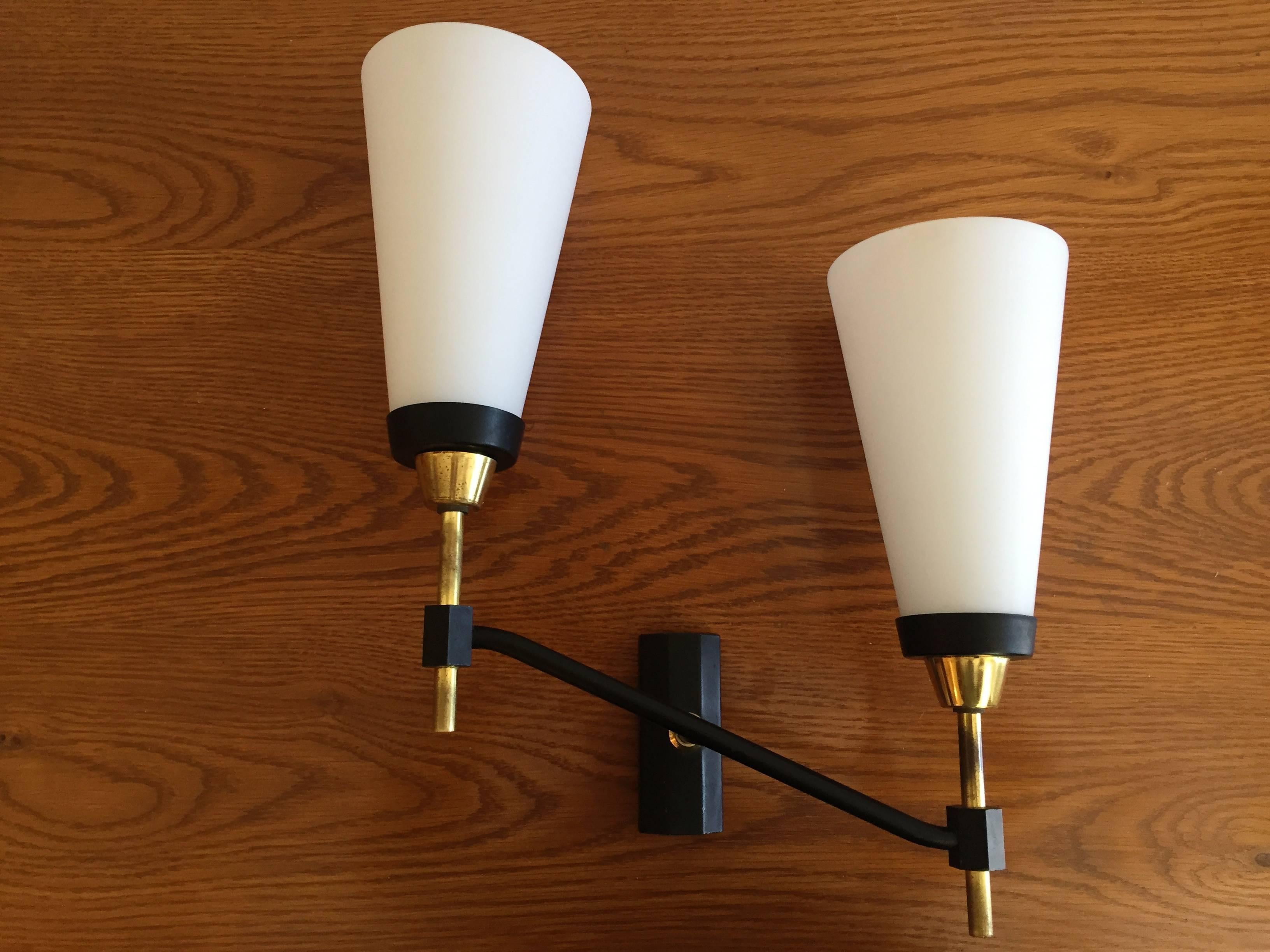 Great large 1950s French sconces composed of brass and matte black fixtures holding large white matte glass shades. Rewired.