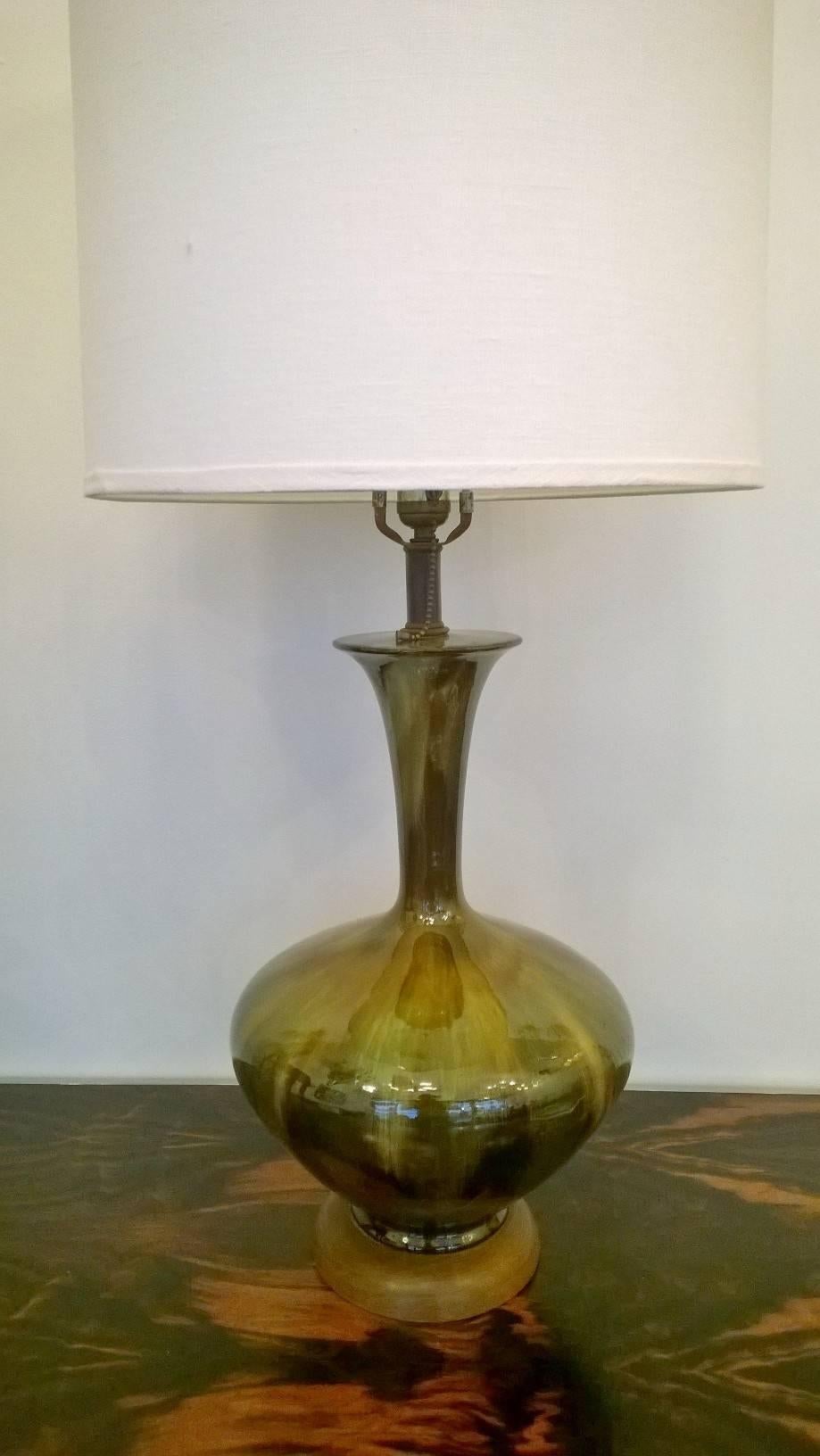 An original pair of 1950s Italian art pottery lamps done in shades of green with walnut bases.