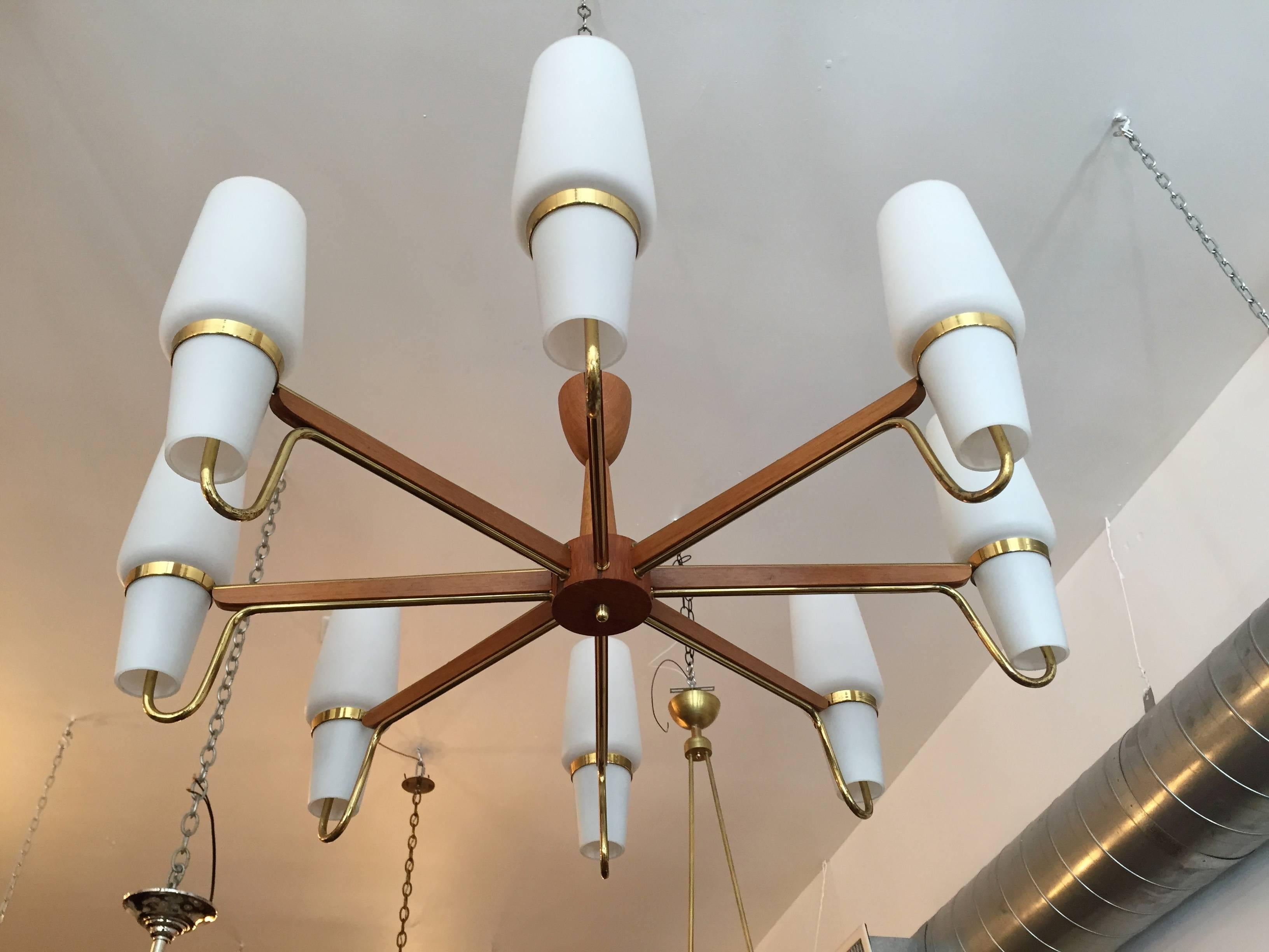 A wonderful original 1950s Danish chandelier done in polished brass and teak with white matte glass shades, rewired.