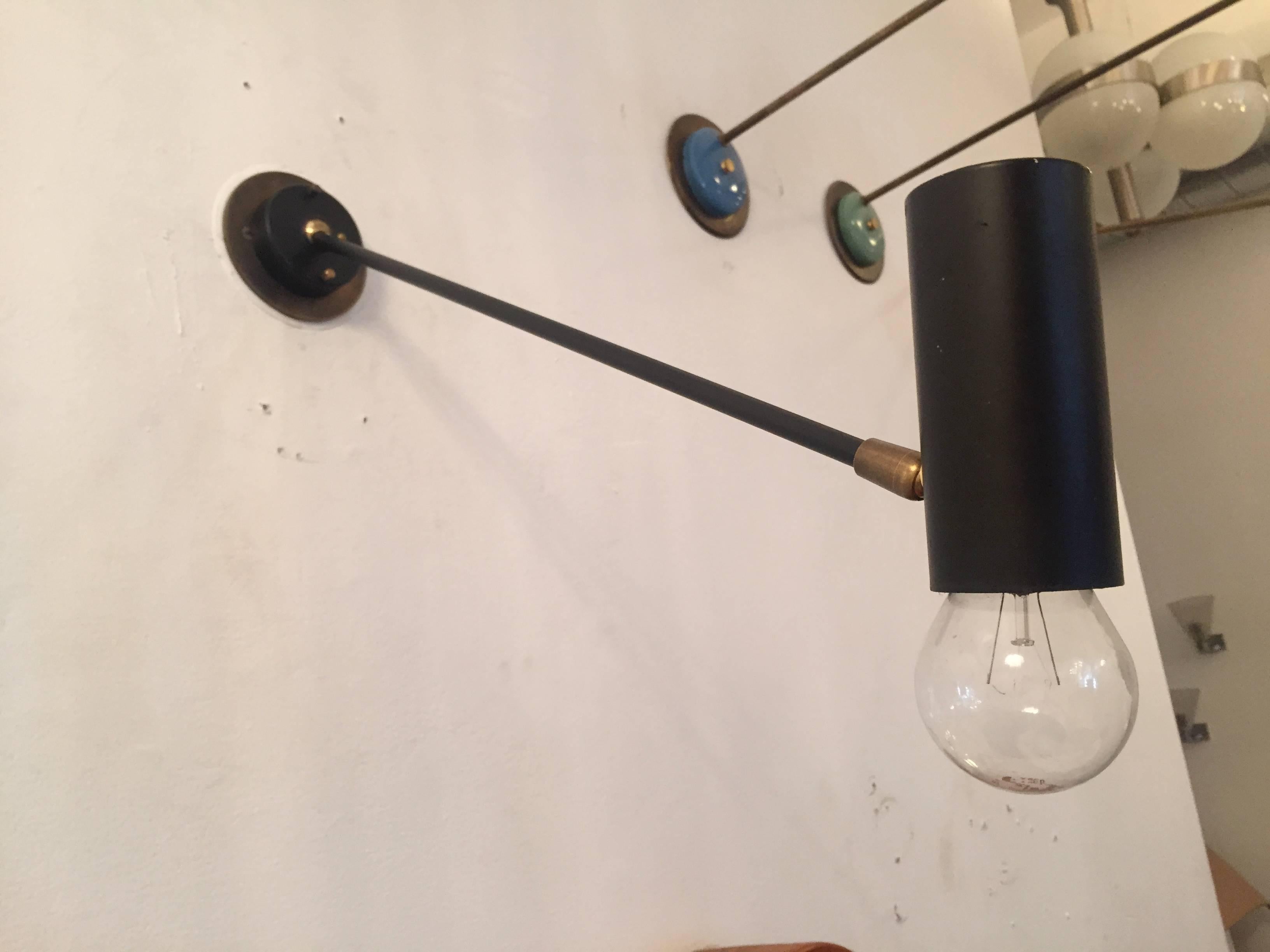 A great original pair of Directional 1950s wall lights composed of a matte black and aged brass body. The head as well as the arm pivots. Rewired.