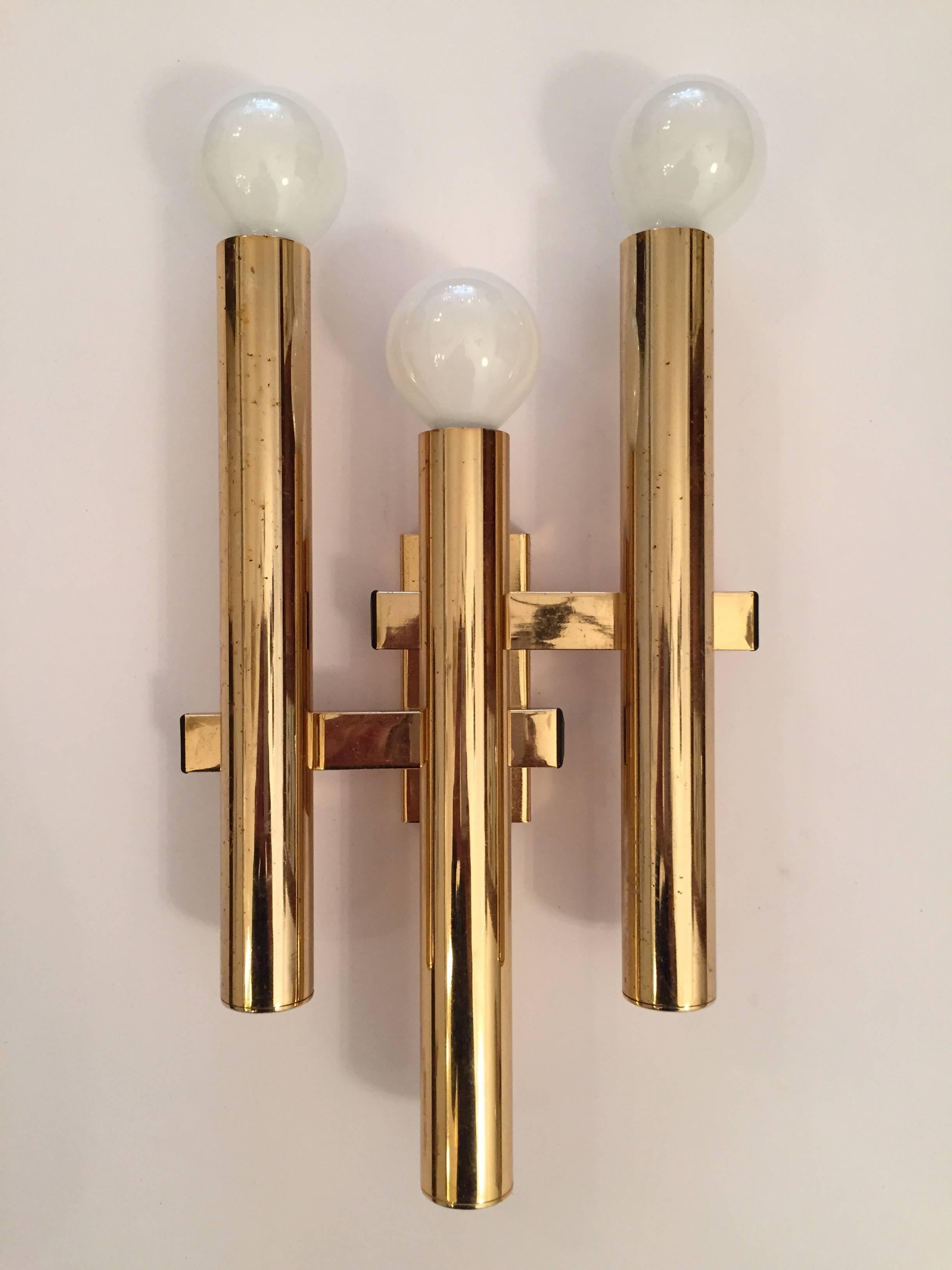 A great sleek pair of 1960s polished brass "Space Age" sconces by famed Italian lighting maker, Sciolari. Rewired. Three-light sources.