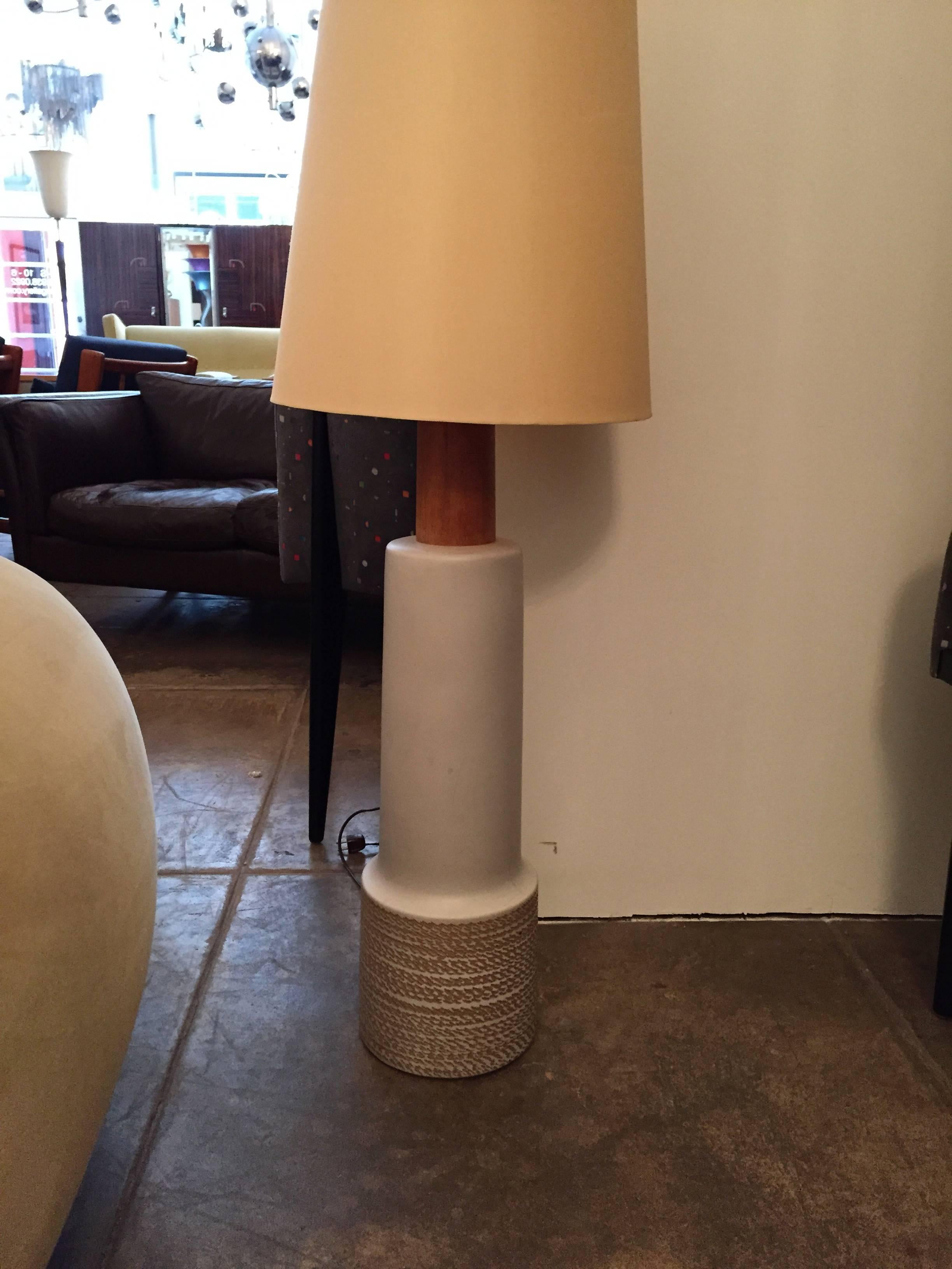 A great large art potter floor or table lamp by the famed American art studio. Martz. The pottery base if white with a cream incised pattern and a walnut neck and matching wood finial. Signed. Can be used on the floor or on a low table. It has the