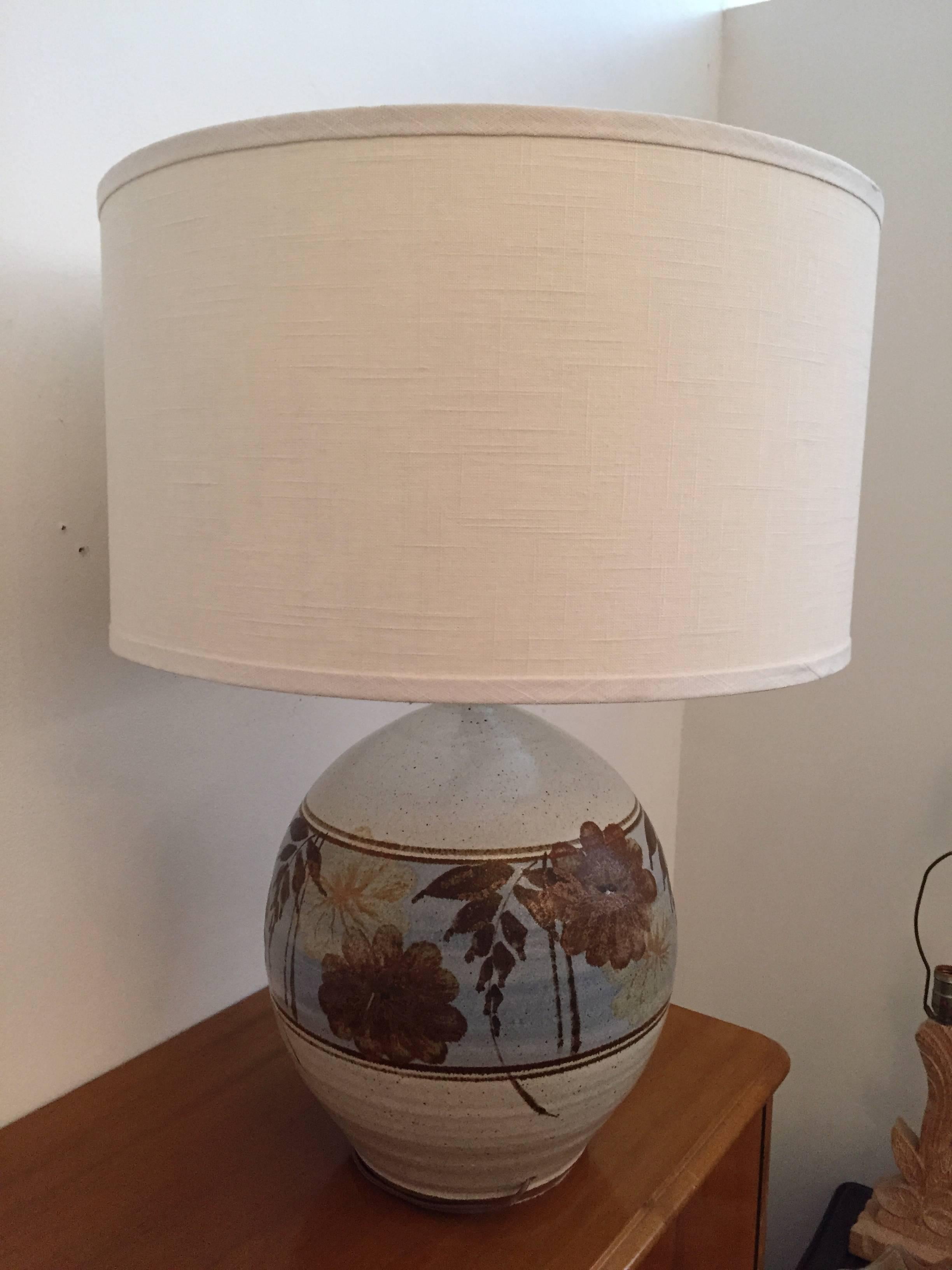 An original pair of 1970s, California, Mid-Century Modern art pottery stoneware table lamps. The ball shaped ceramic lamps are done in muted colors of beige, brown, and blue. Newly rewired. Made by California Ceramic Company.