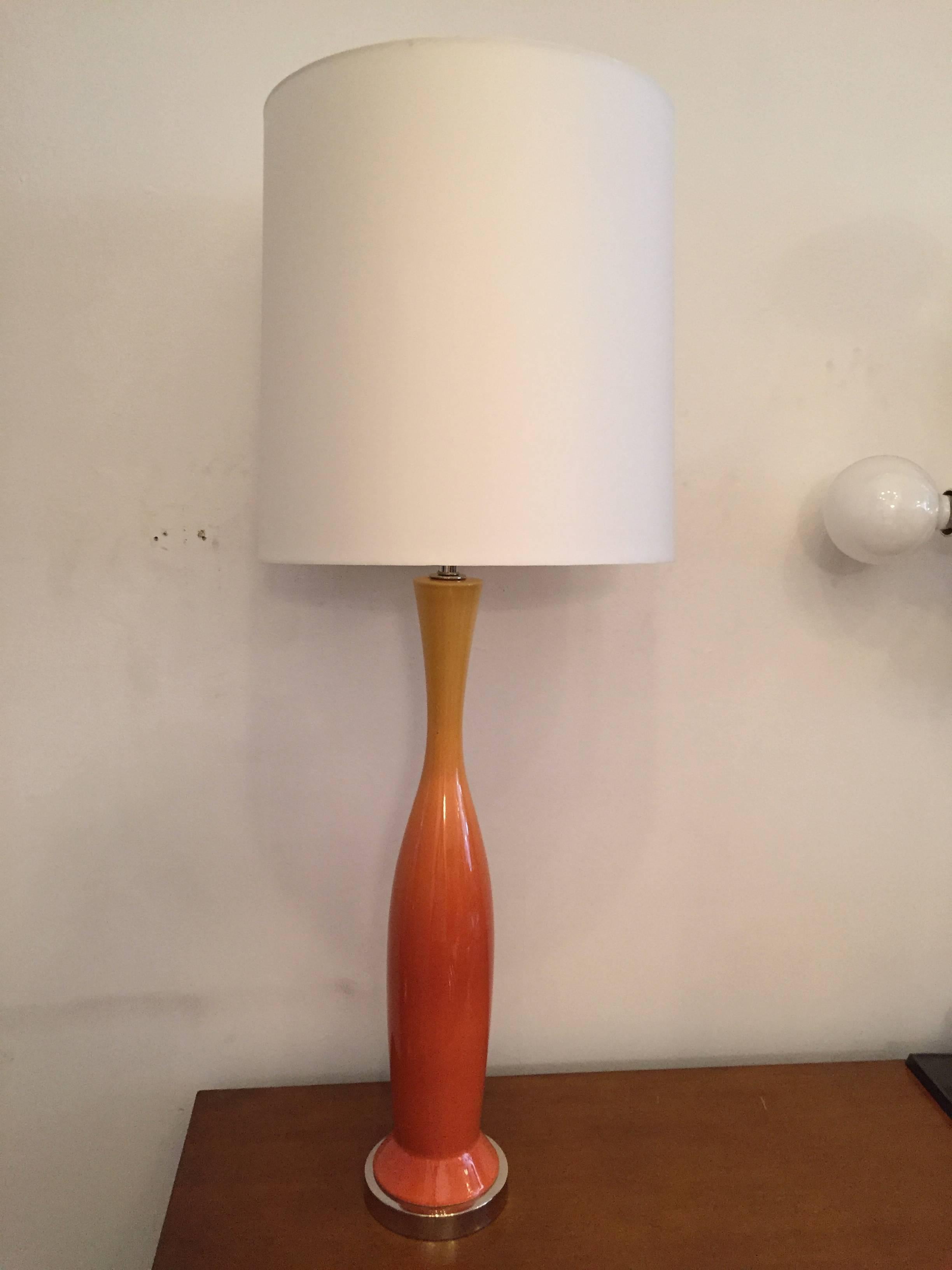 A sleek, colorful large pair of Italian Mid-Century Modern glazed pottery lamps with polished nickel hardware. The ceramic bodies are in colors of orange to yellow. Newly rewired in excellent condition. The height with shades shown is 42