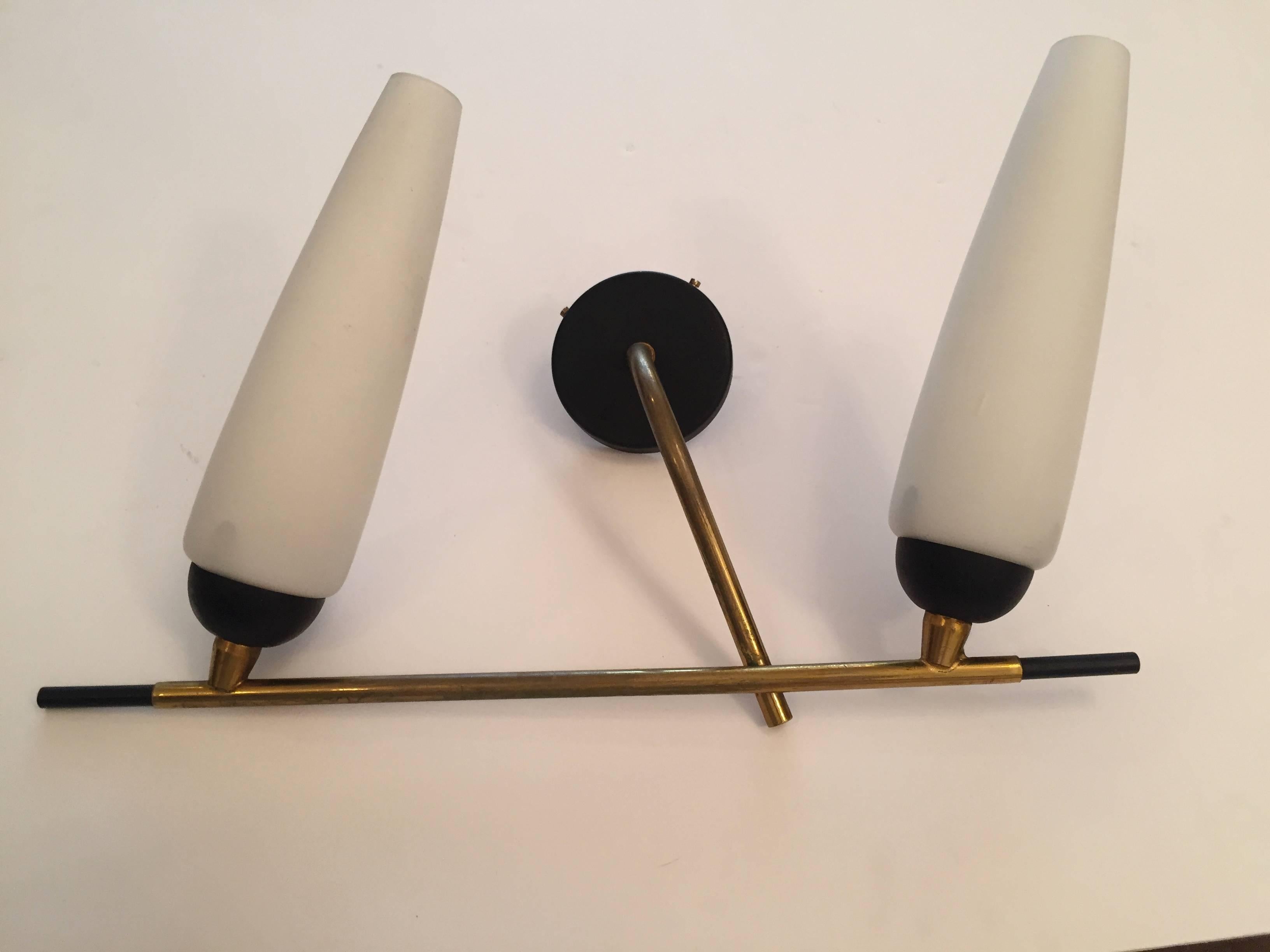 A great pair of French, 1960s sconces by Lunel. They are composed and an aged brass and black enamel frame holding white tube glass glades. Newly rewired.