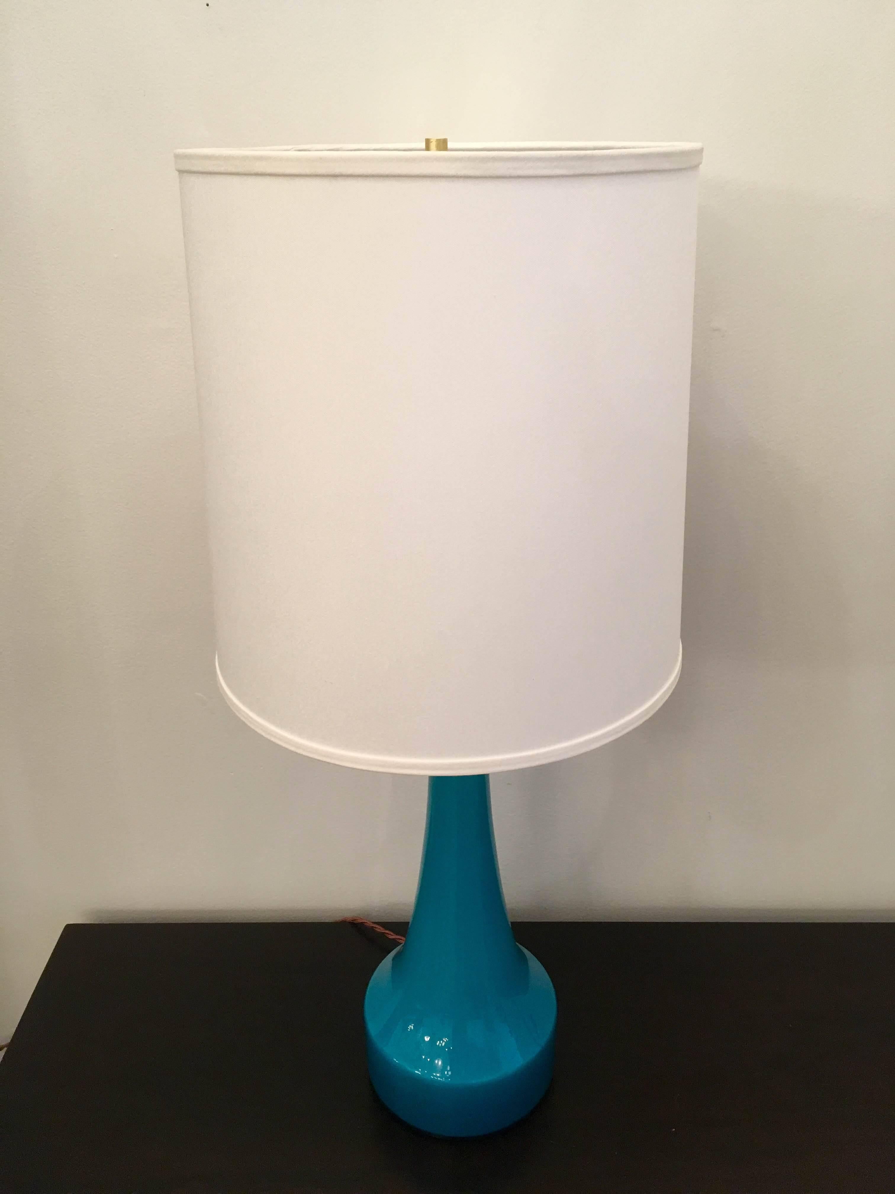 A pair of vibrant blue glass table lamps by Swedish glass maker, Holmegaard. Newly rewired with silk cords.