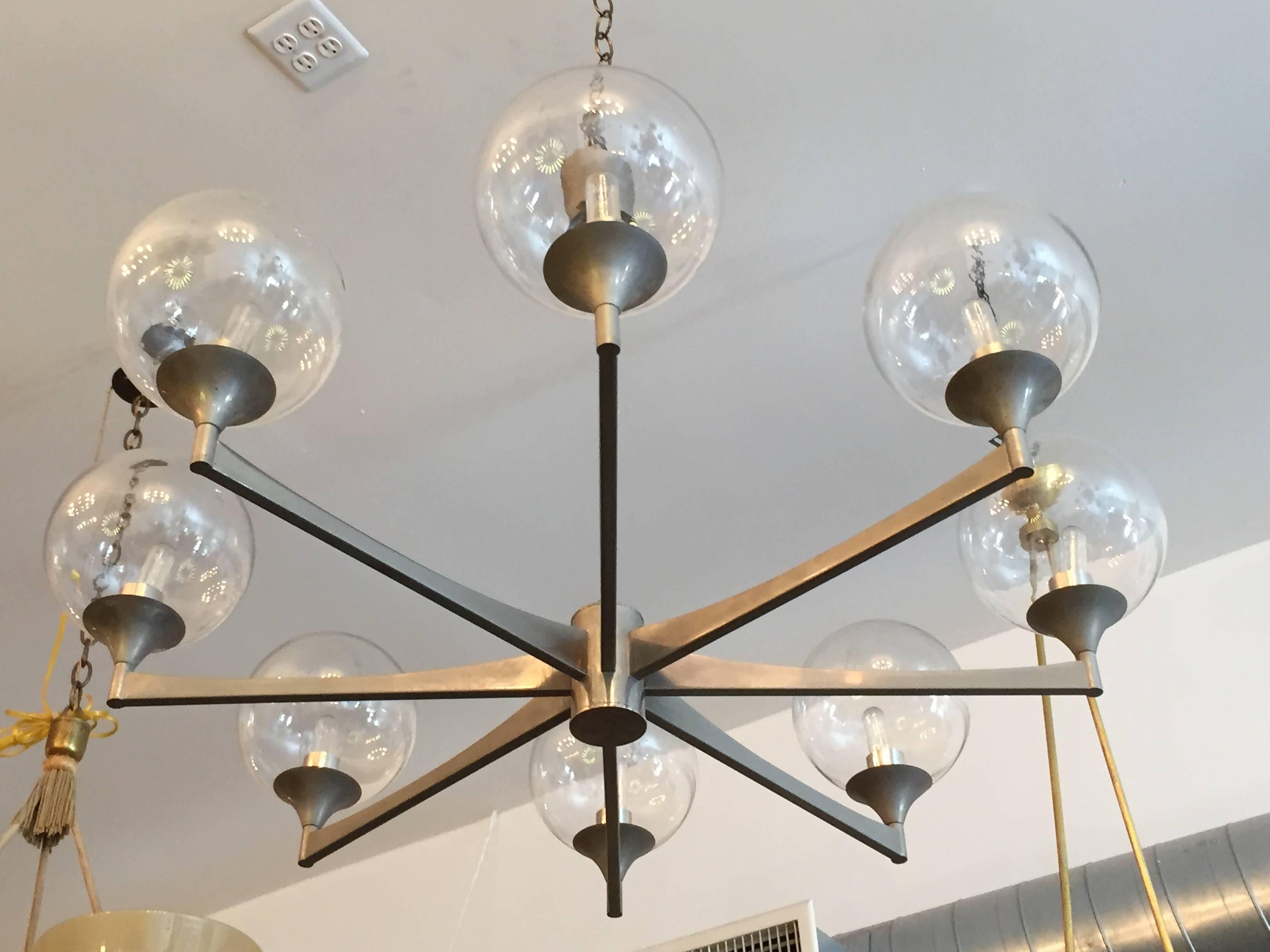 A simple sleek modern 1970s Italian chandelier by the famed firm, Scolari. The chandelier body is done in a matte steel and holds clear glass globe shades. Newly rewired.