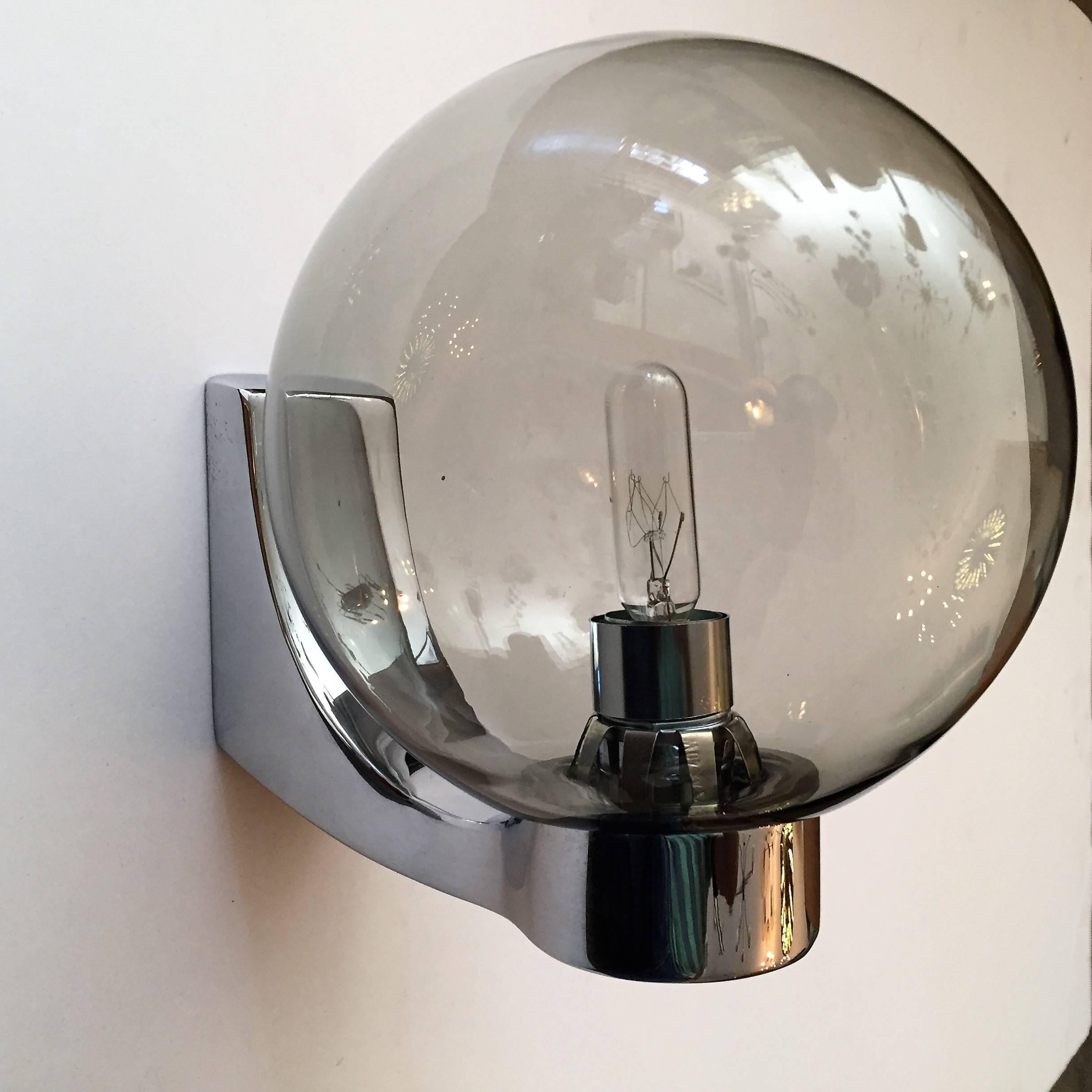 A great set of 1960s German wall lights composed of polished chrome fixtures and lightly smoked glass globes, new old stock, never used, rewired by Hillebrand.