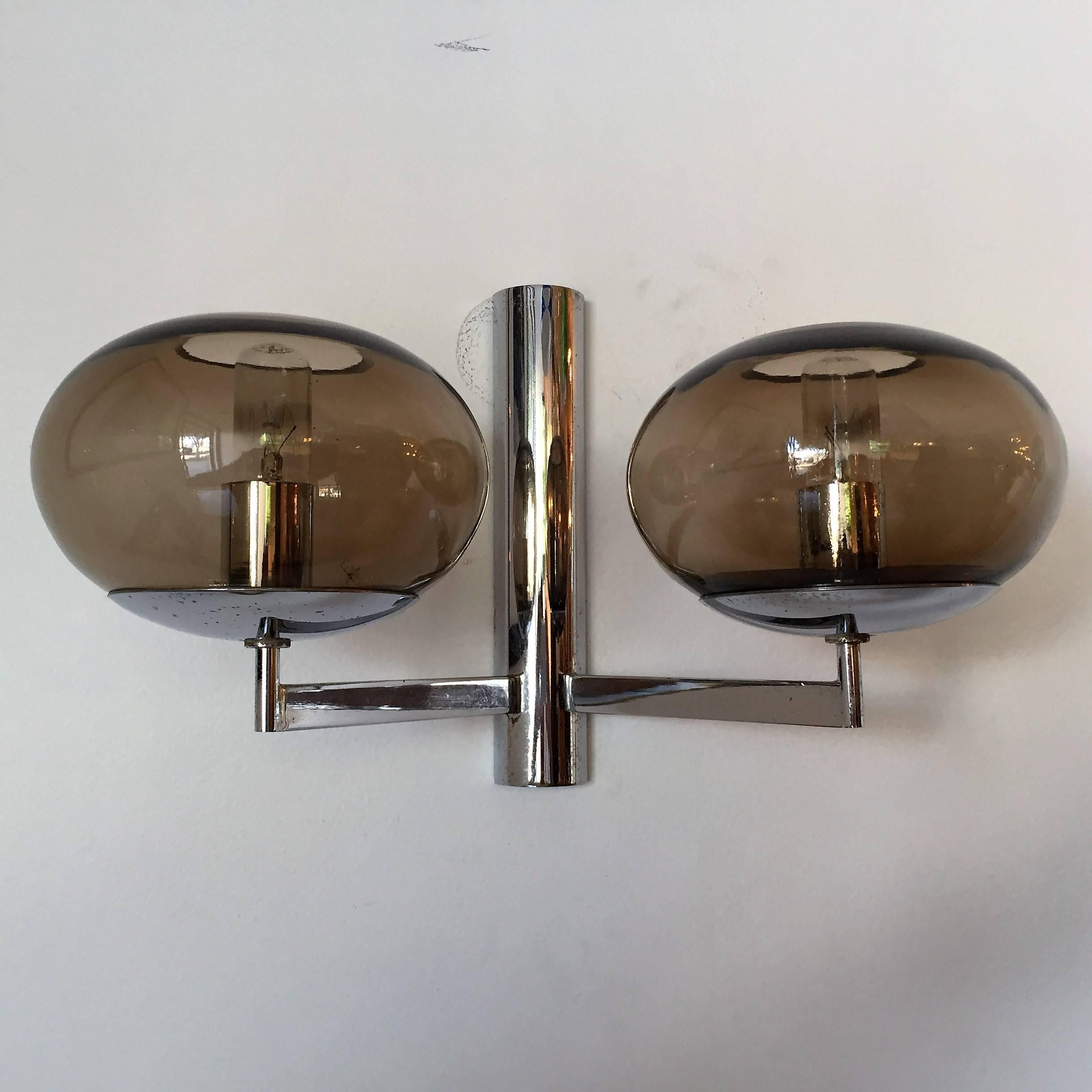 A great pair of 1960s modern sleek sconces composed of a polished chrome fixture and two smoked glass globes by the famed lighting company, Sciolari. Newly rewired. One large three globe wall light also available.