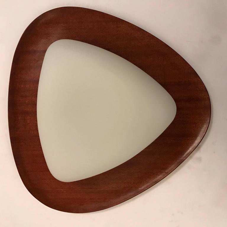 An original pair of 1960s Italian flush or wall lights by the lighting maker, Reggiani,. The lights are composed of a teak wood frame and a white triangular glass shade. Rewired.