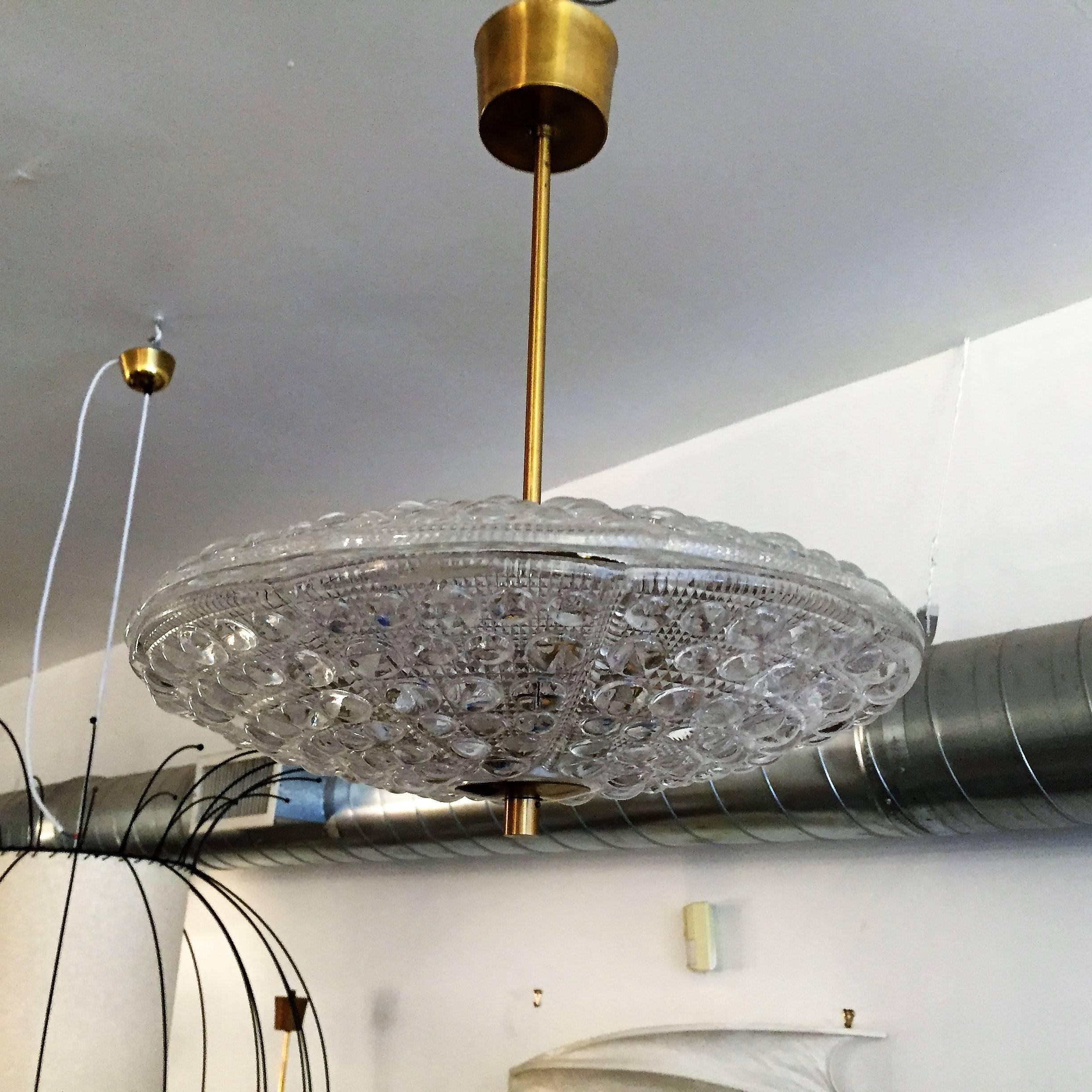 An original 1950s Orrefors crystal glass Swedish pendant designed by Carl Fagerlund. The light is composed of two heavy textured glass shades and aged brass fittings, six-light sources. Rewired.