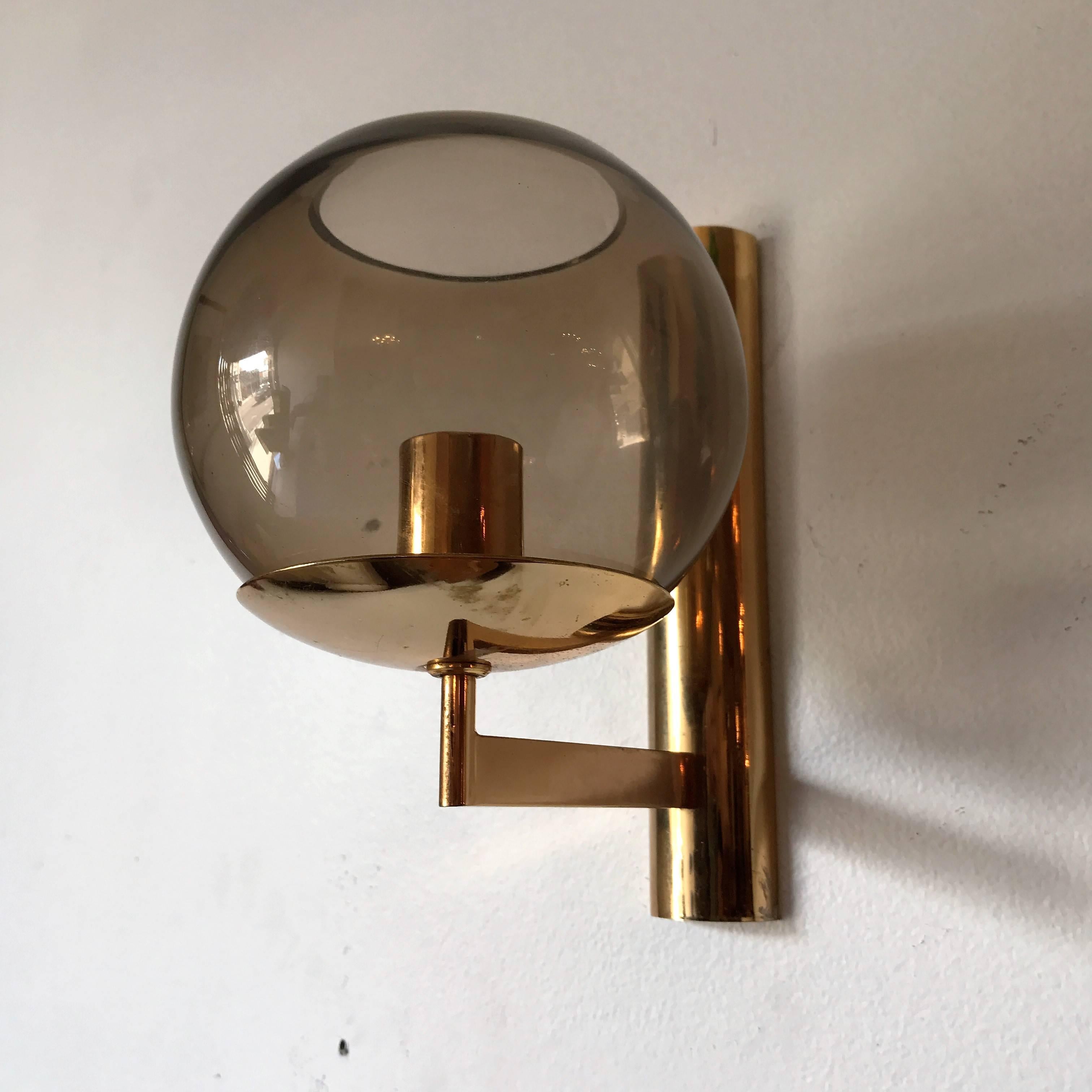 A great modern pair of 1970s Italian sconces by Sciolari. The wall lights are composed of polished brass frames and smoked glass globes, Rewired. Matching pendants and larger sconces available.