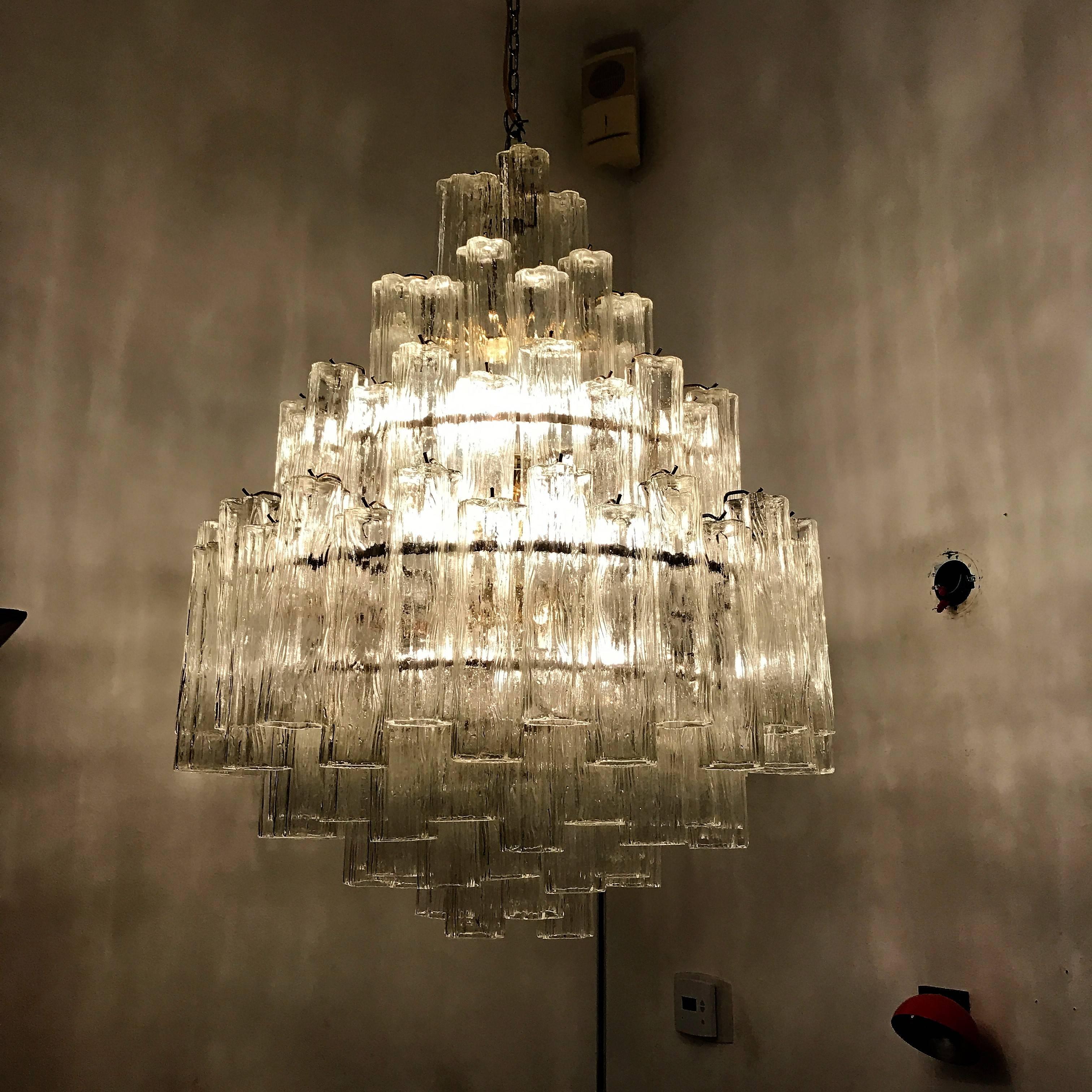 A beautiful 1970s Murano glass chandelier composed of an polished brass frame and driven tiers of "tronchi" glass tubes. Newly rewired.