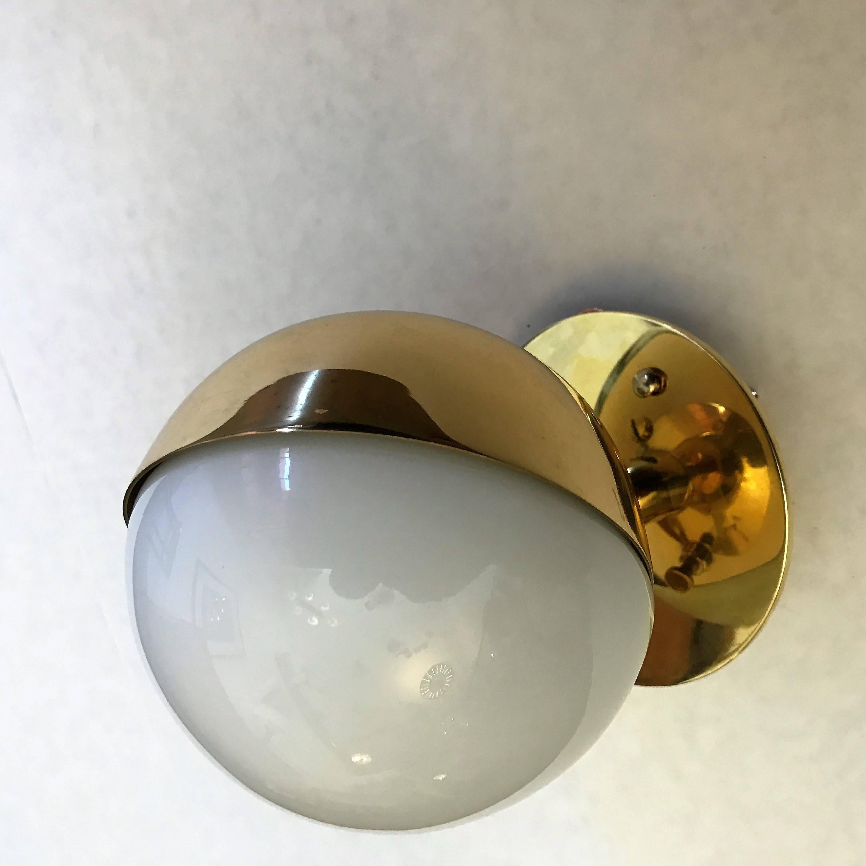 An original set of three  Bauhaus style 1920s polished brass and white opaline glass wall lights designed by Vilhelm Lauritzen for Poulsen. Rewired. The lights can tilt and be set in the optimal direction with its set screw.