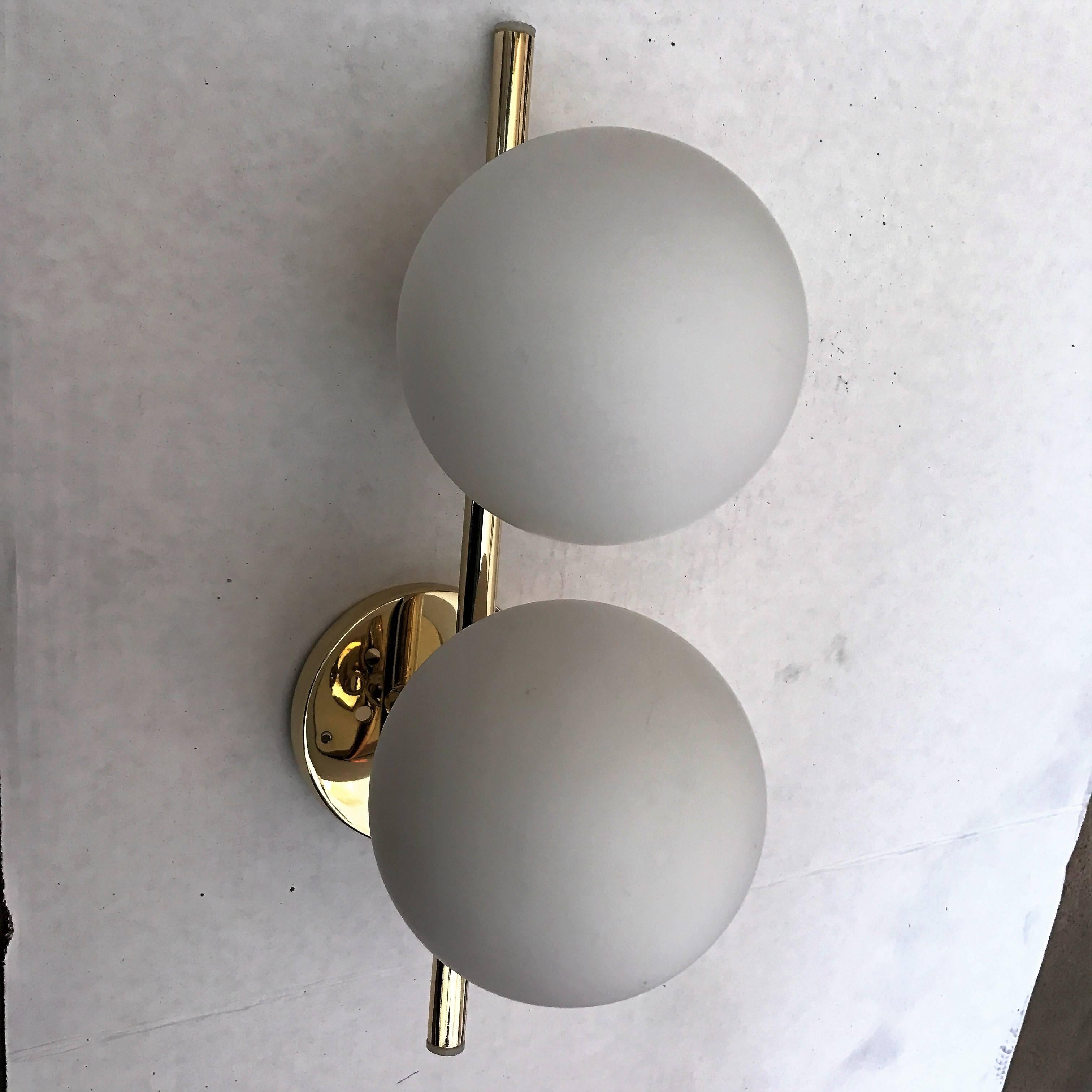 A great pair of 1950s Italian simple and sleek wall lights composed of polished brass bodies and white frosted glass globe shades. Newly rewired.