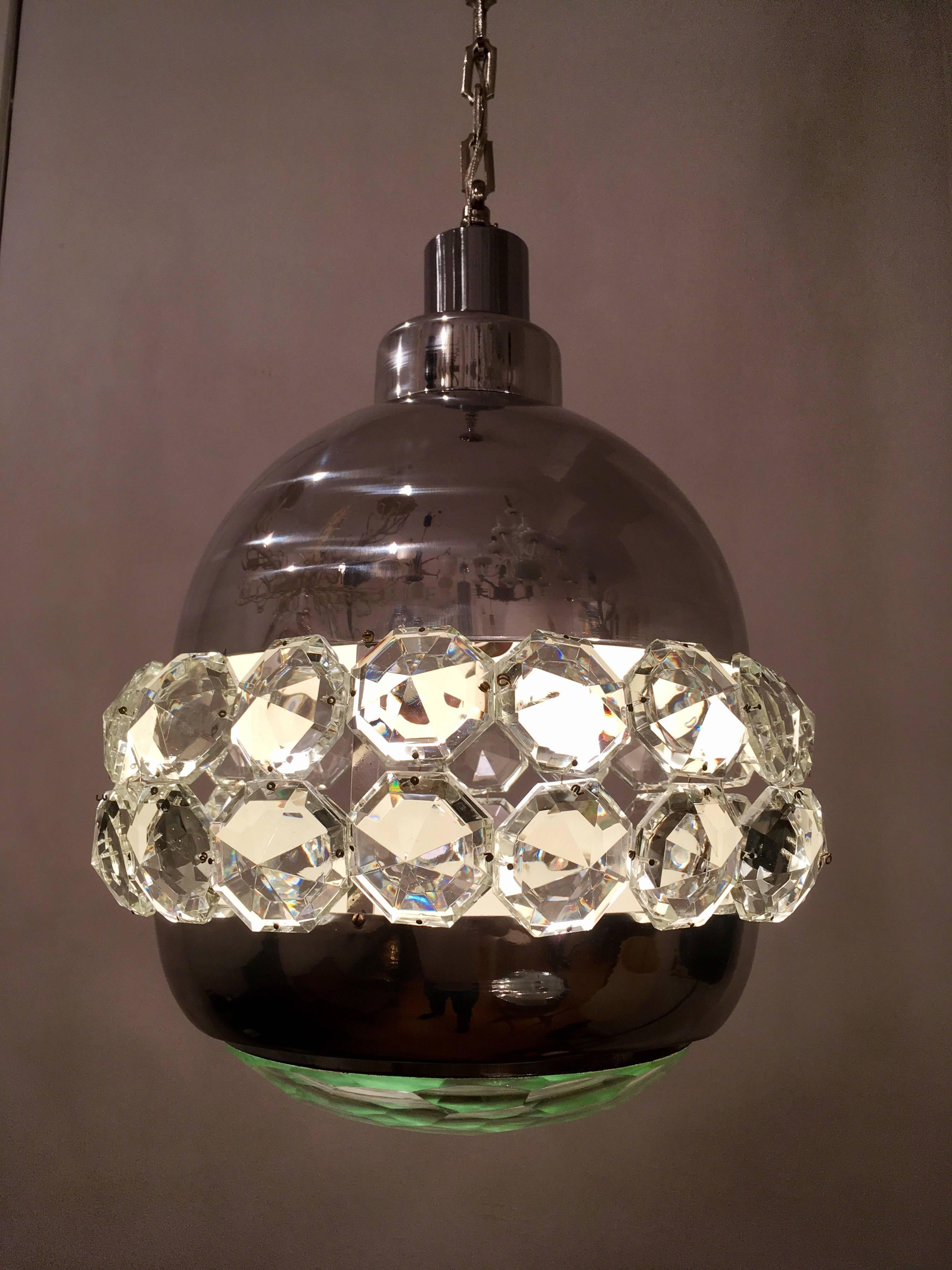 An original 1970s Italian pendant by the famed lighting company, Lumi. The chandelier is composed of a high polished and satin chrome fixture with numerous large thick crystals and one large crystal shade. Newly Rewired.
Overall height 59".