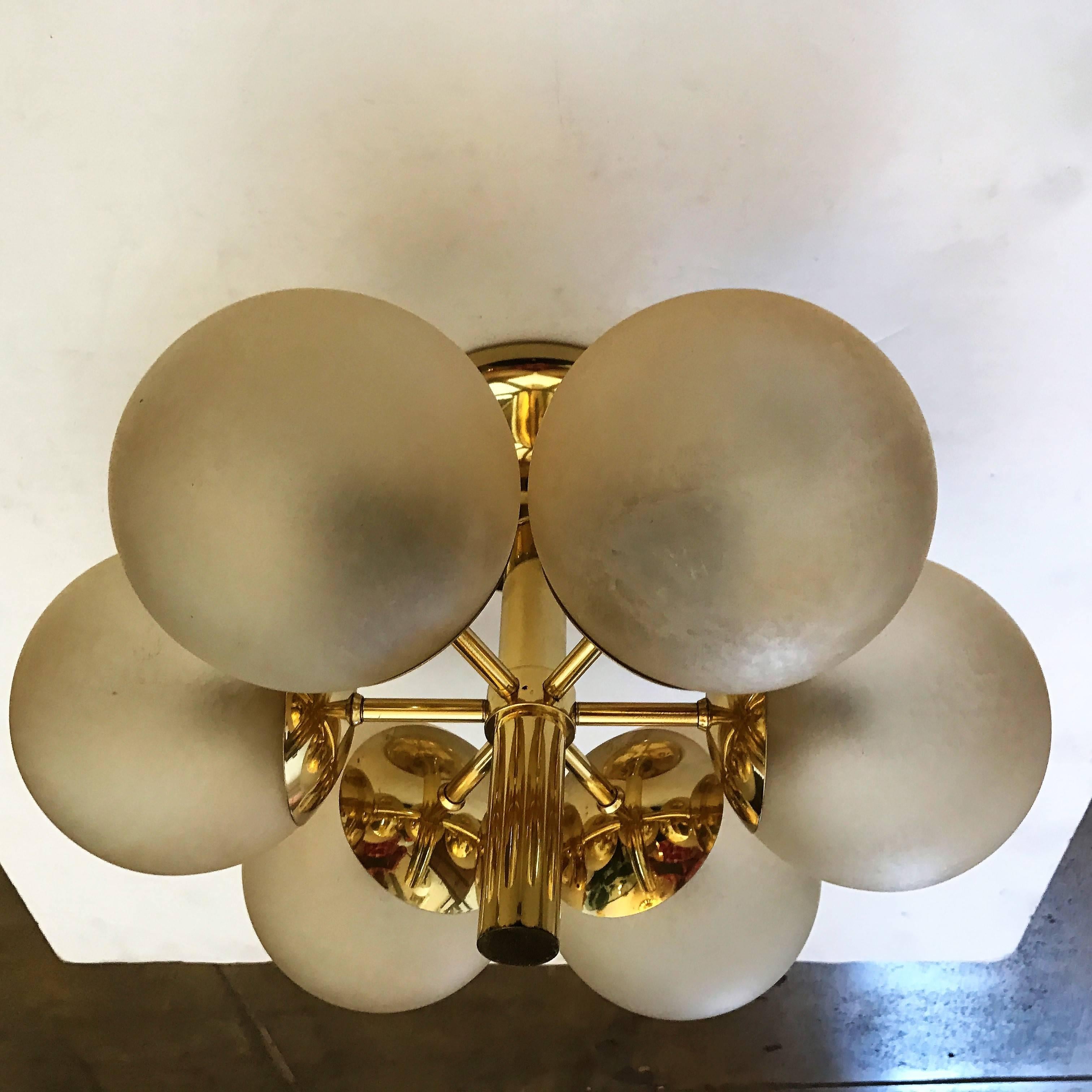 A beautiful 1970s German space age flush light or chandelier composed of a golden brass fixture with golden frosted glass globe shades by the lighting company, Kaiser. Six light sources. Newly Rewired.