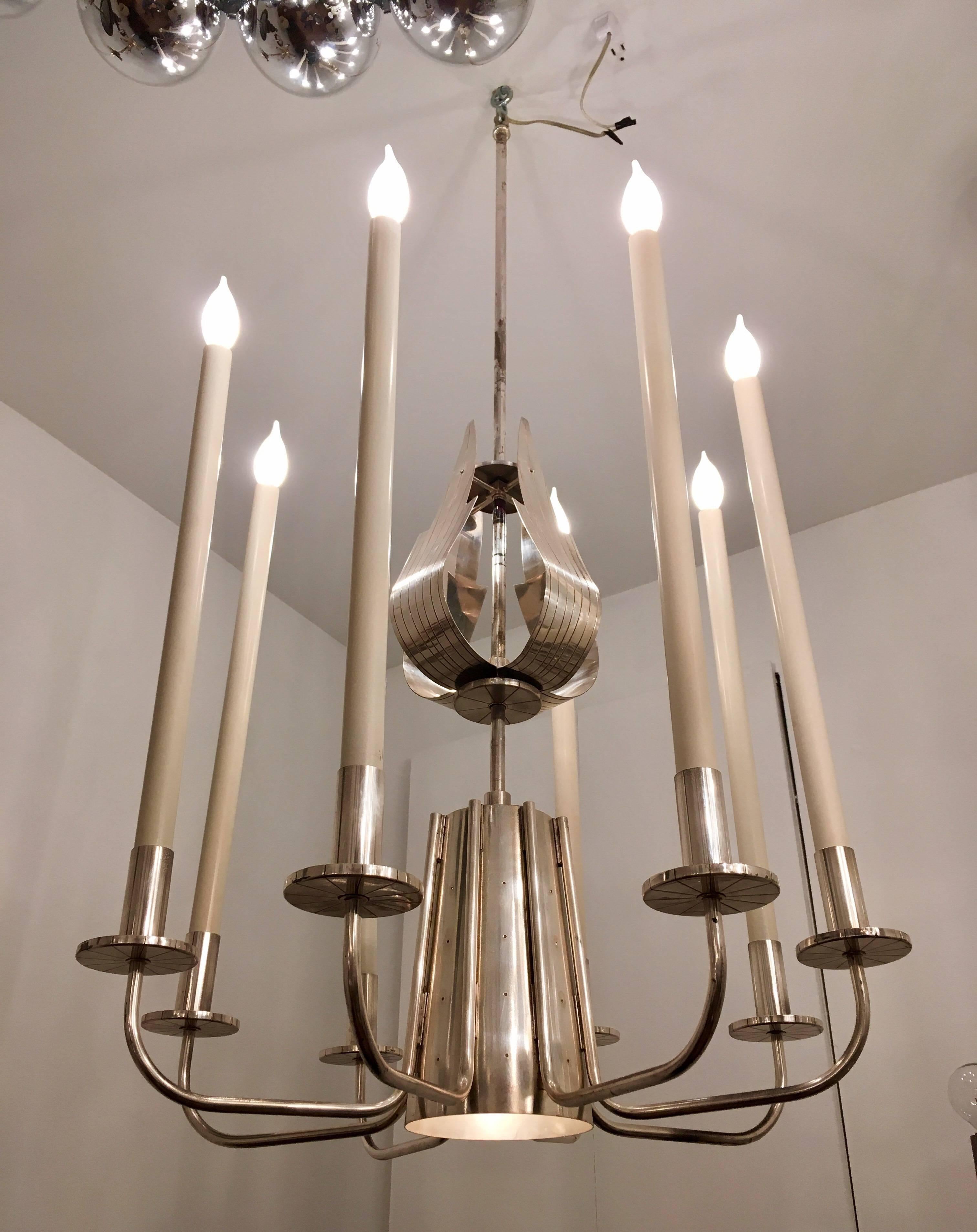 An original, elegant 1960s Tommi Parzinger design in plated silver with hand tooled decorative elements. Nine-light sources, including the large downward light. Newly rewired. A rare and beautiful design.

Bio:
Tommi Anton Parzinger (1903-1981)