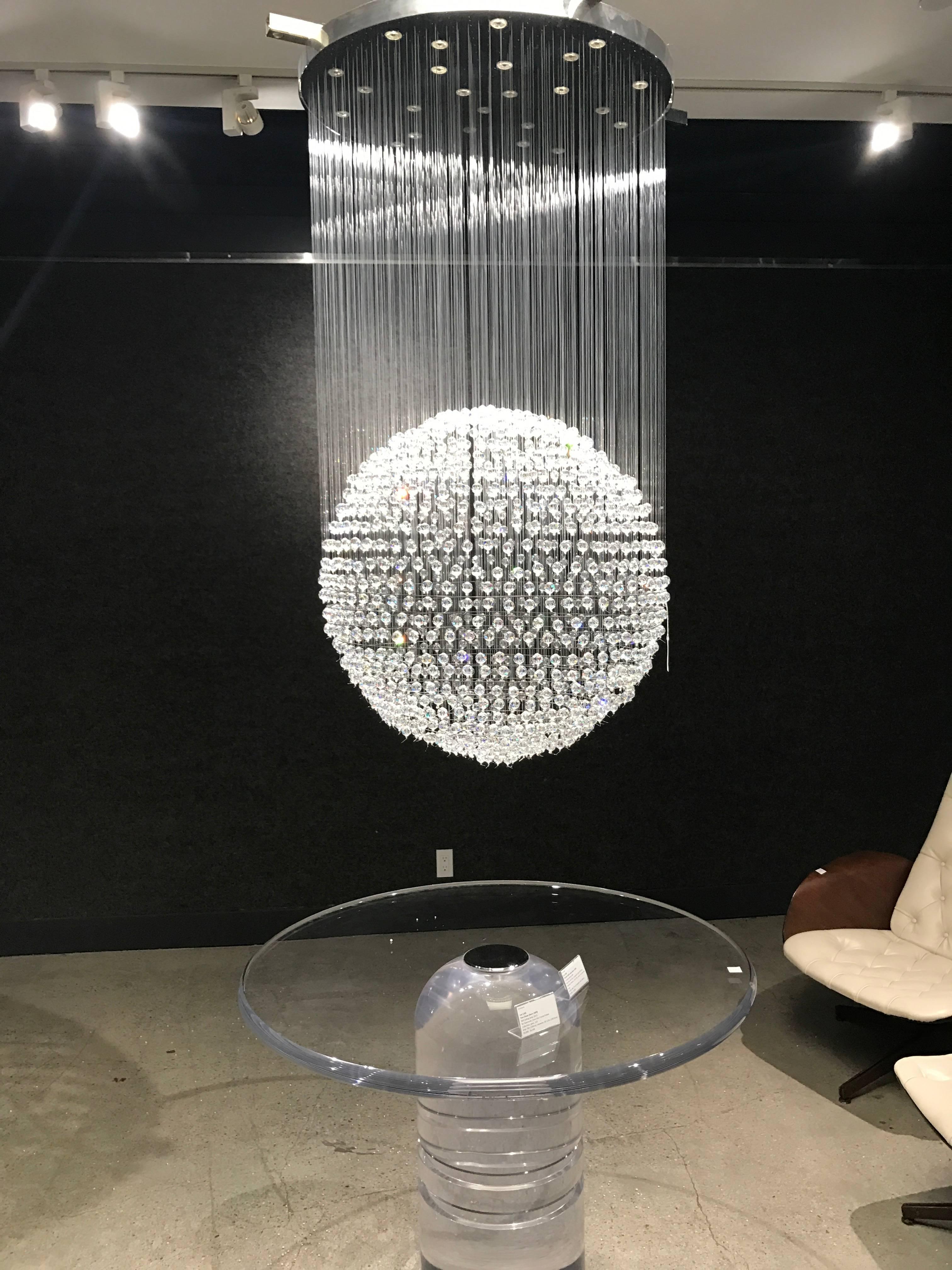 A rare limited edition Tom Dixon designed chandelier for Swarovski for the Crystal Palace collection. The chandelier is composed of a polished chrome fixture with hundreds of large Swarovski crystals hanging from clear threads to form one large
