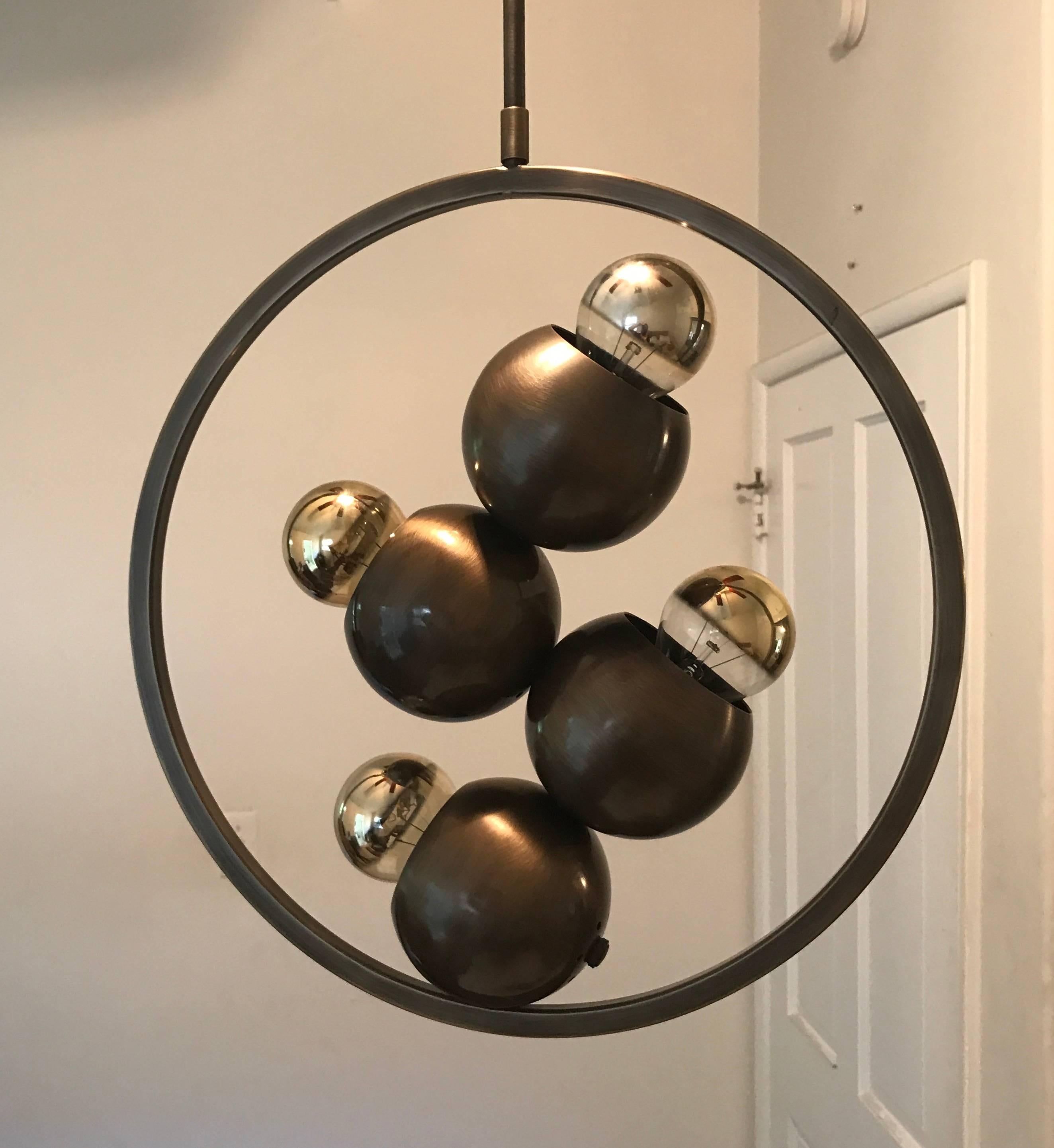 A set of 1960s Italian aged brass pendant with four lights in a Space Age Molecule style. One pendant with lights facing up and the other with lights facing down. A rare modern form with a traditional metal finish. Newly Rewired with four standard