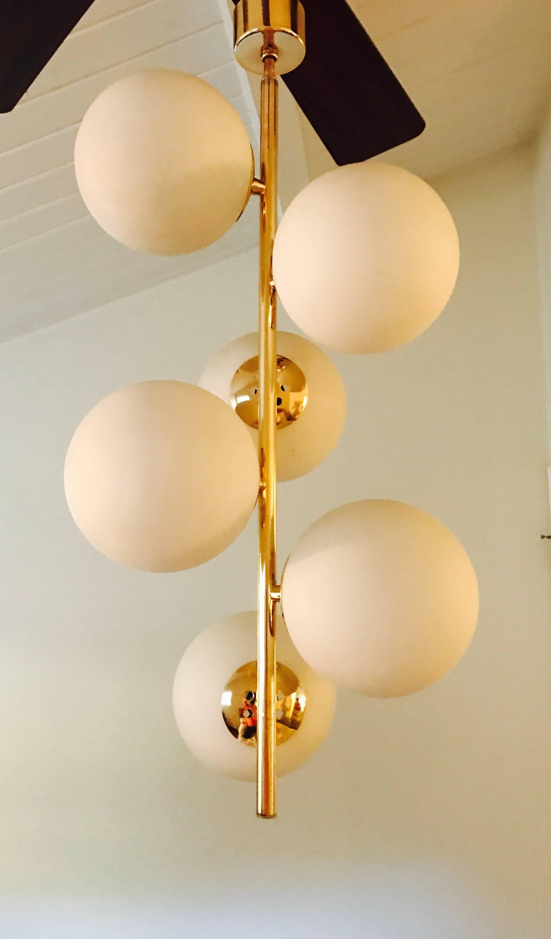 A wonderful 1960s pendant composed a long polished brass pole body with six large white glass globe shades. Newly rewired.