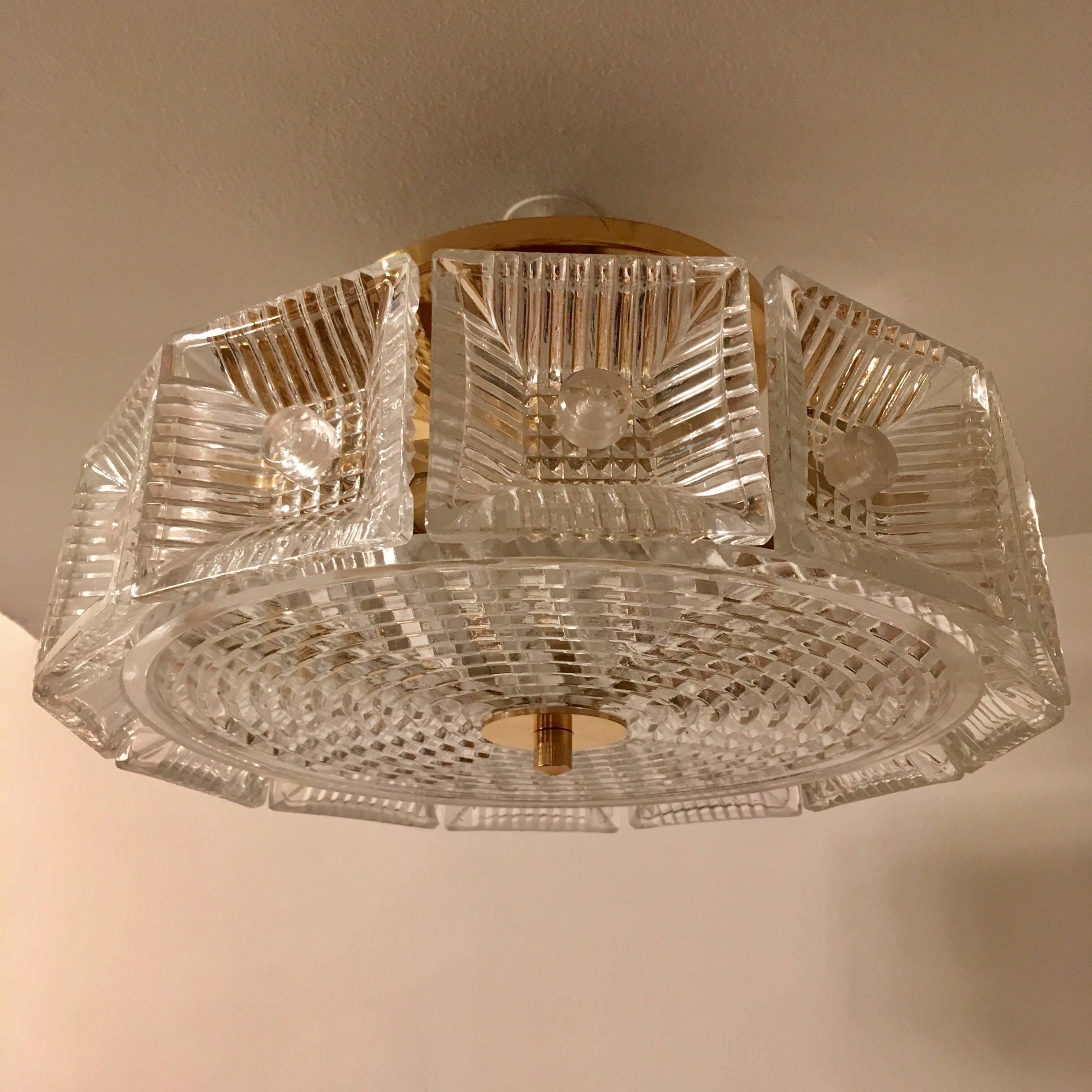 An original thick heavy chunky crystal flush pendant or hanging chandelier with golden brass fittings made by the famed Swedish crystal maker, Orrefors. Newly rewired.
Located in our New York City Chelsea location.