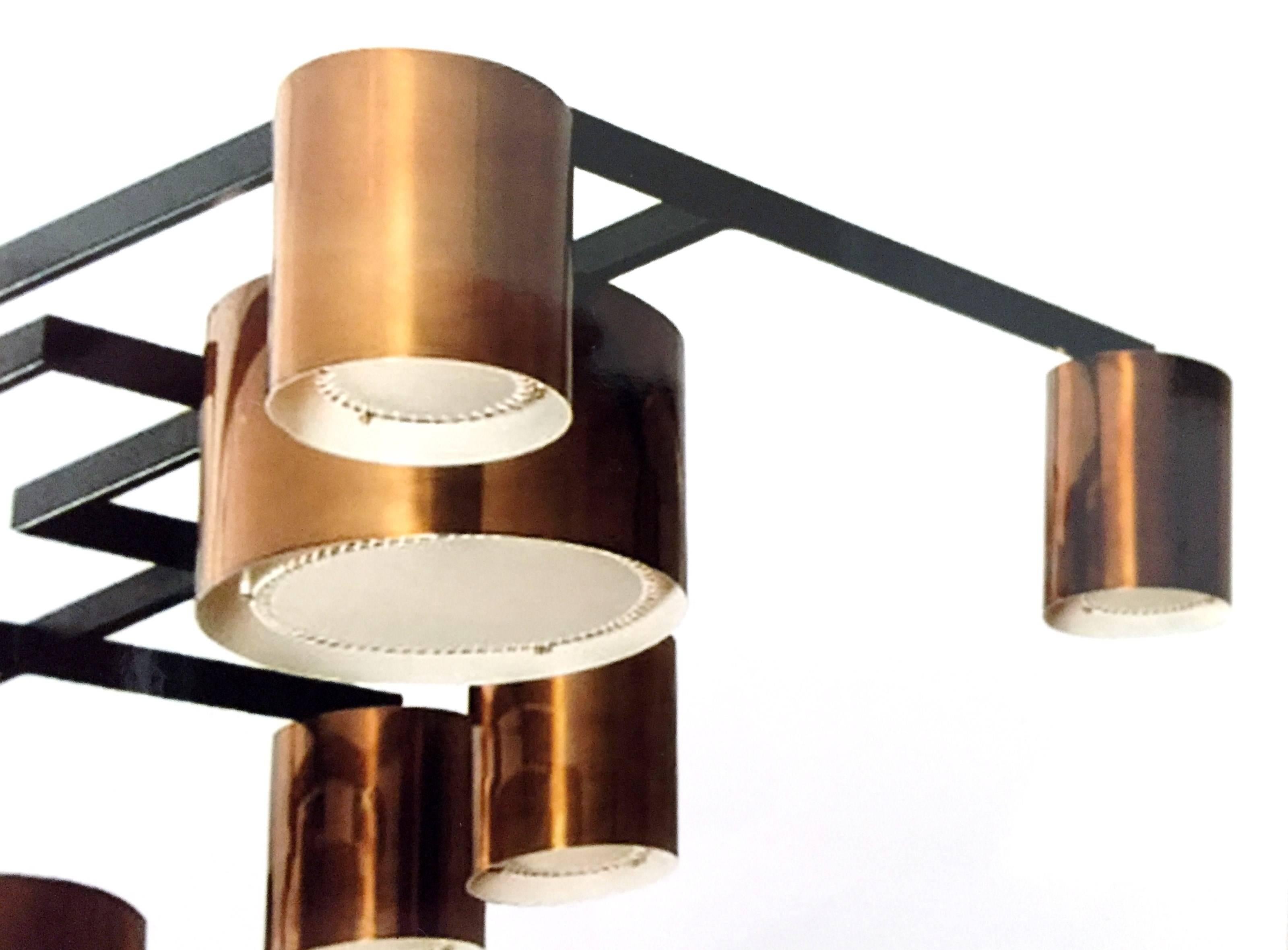 Impressive asymmetrical rectangular ceiling fixture by Diego Mardegan; the angular framework in black-painted steel with cylindrical lamp holders of two sizes (7" diameter and 10" diameter) in spun brass with laced parchment diffusers.