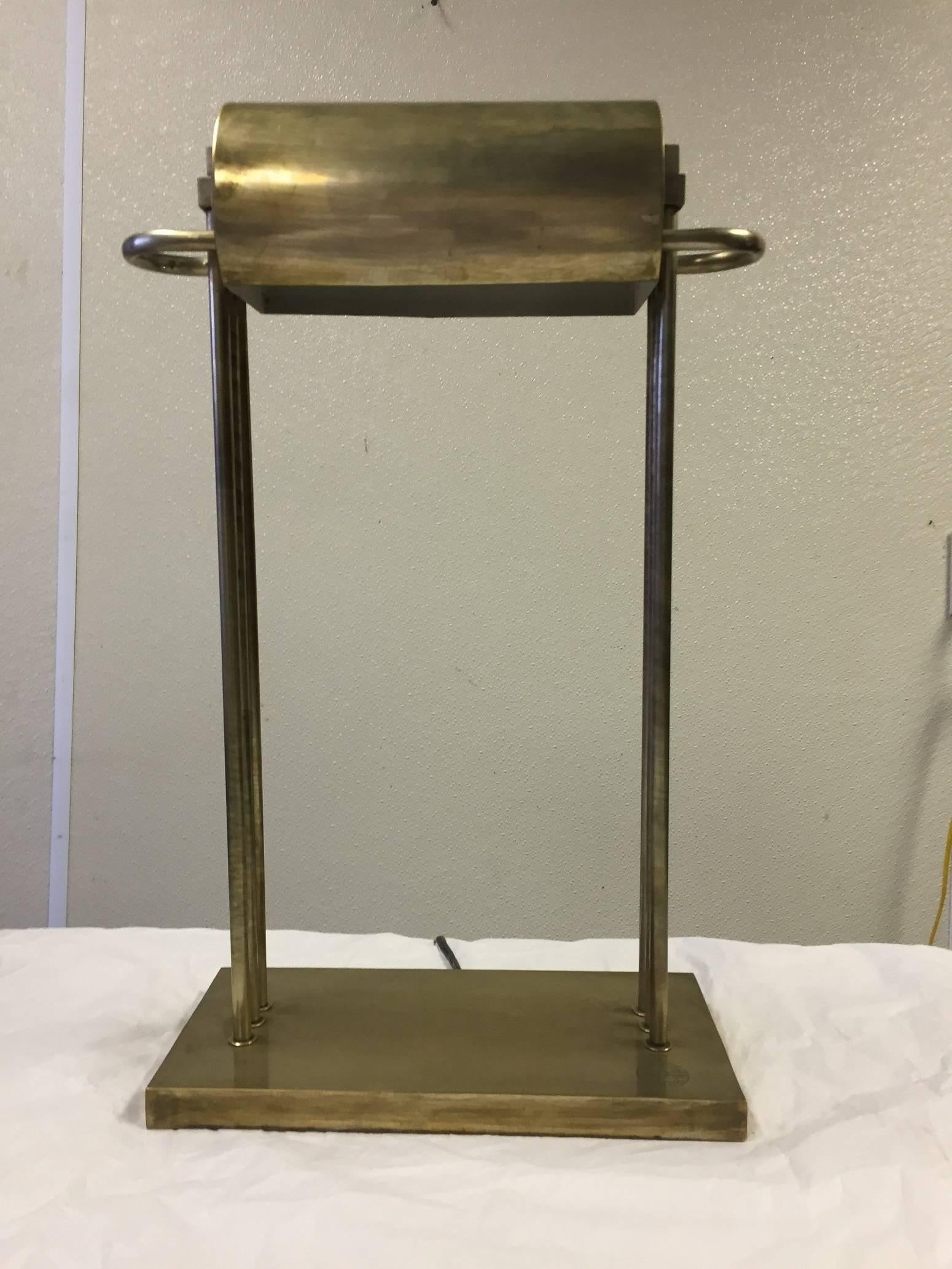 Two available. Table lamp in heavy brass designed by Marcel Breuer and presented at the 1925 Paris Exhibition, the cylindrical shade connected to a rectangular base by three tubular supports, each lamp is marked (note that one lamp's marking is a