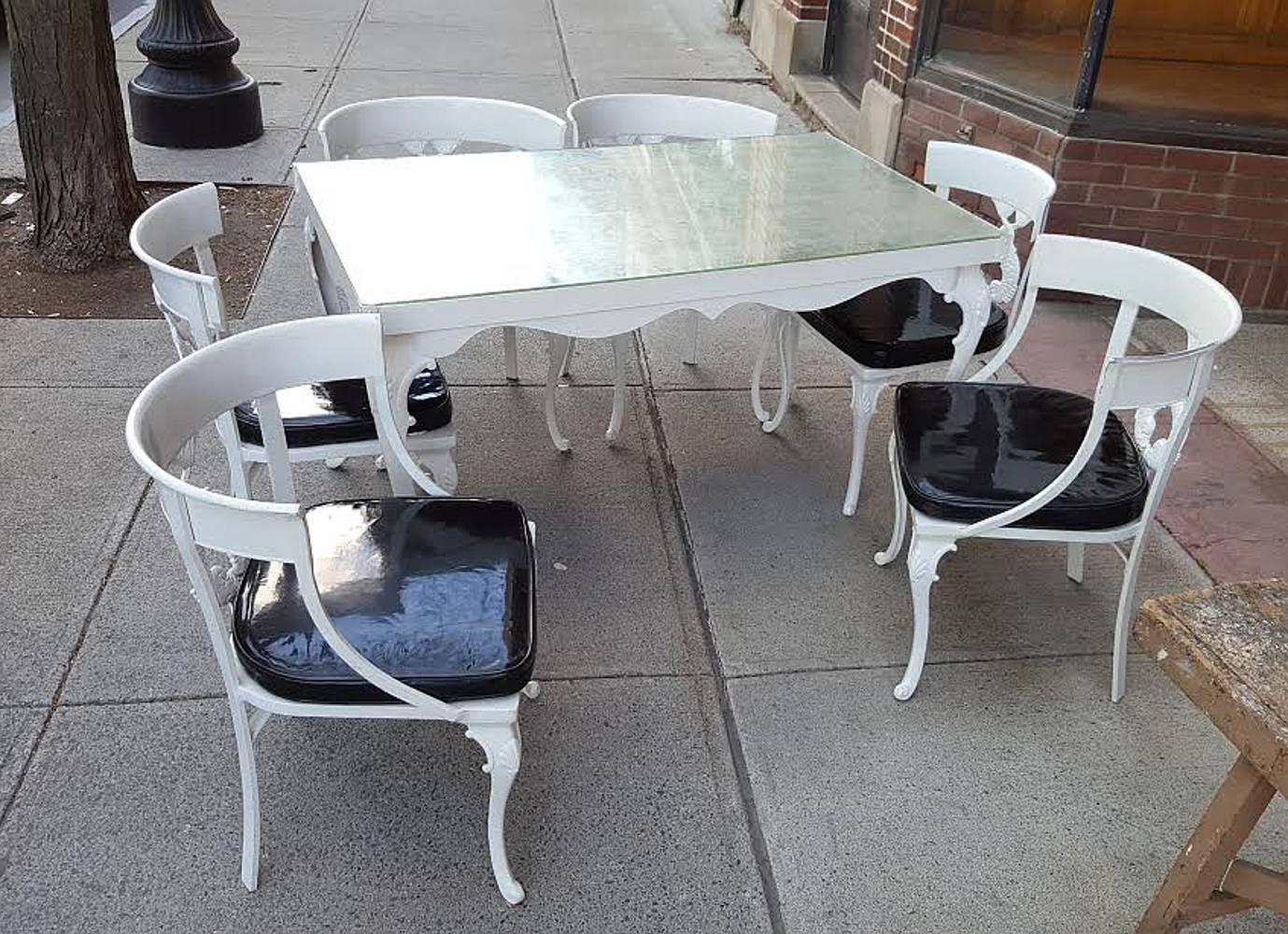 A cast aluminum garden set by Molla in the intertwined dolphin pattern.
Molla is famous for making high quality cast aluminum furniture.
This set contains four armchairs, two side chairs and table with silver leaf glass top.

The table measures