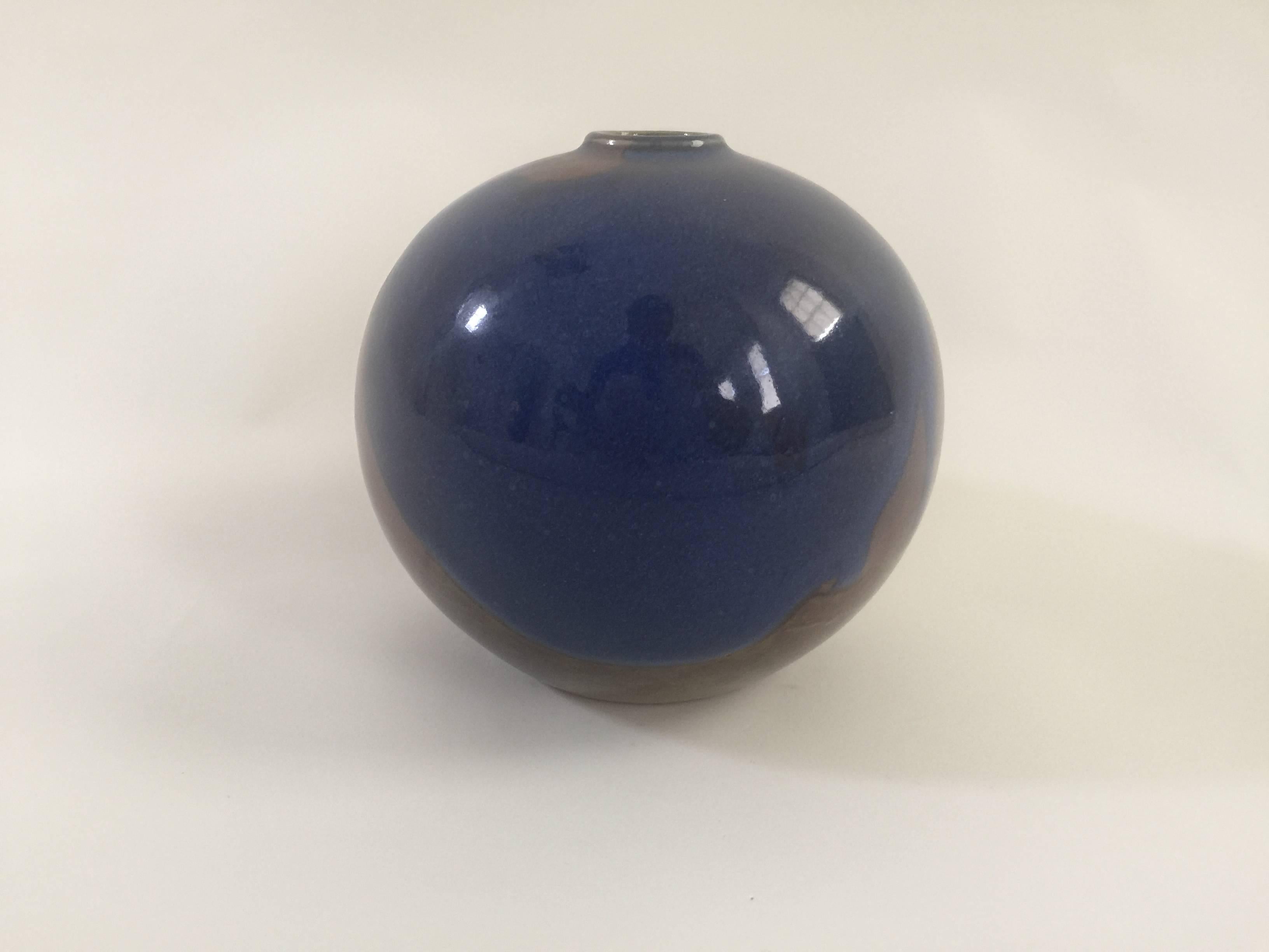 Handmade and hand-painted dark blue and brown glazed ceramic spherical bud vase by artist/designer Diane Love for Mikasa. Japan, circa 1970. Marked with brand stamp at underside.