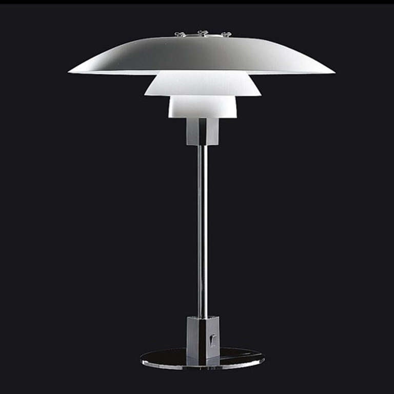 A sculptural desk lamp by Poul Henningsen having a polished chrome stem supporting a concentric three-tiered lacquered aluminum shade, rising from a chromed disc base.
