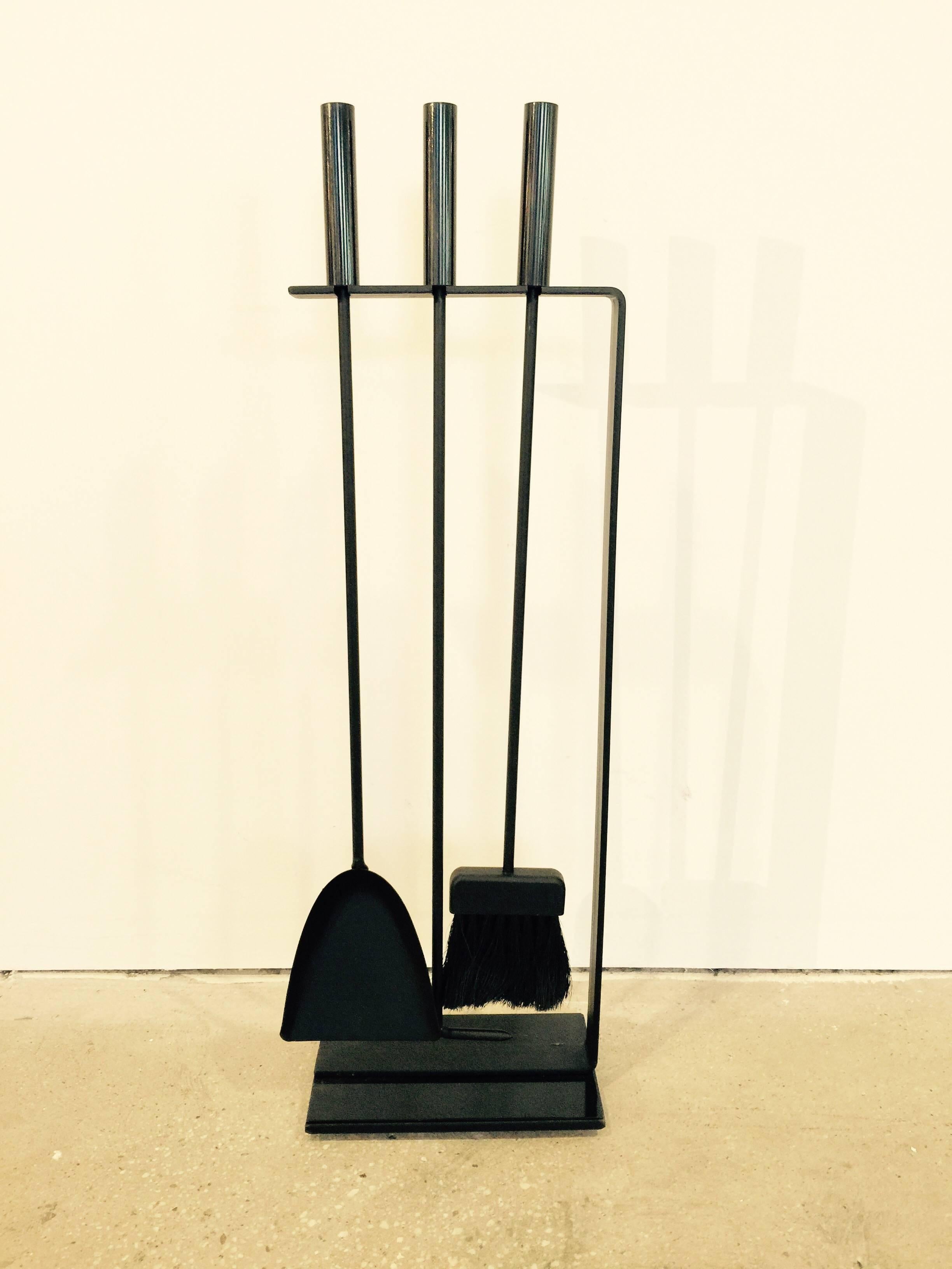 Fireplace tool set with stand by Pilgrim. USA, circa 1960.  Includes stand with three tools: shovel, poker, brush. Matte black iron with gloss enamel base detail and handles. 

Dimensions: 12