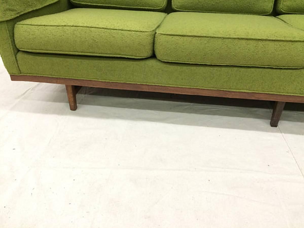 Produced by Thayer Coggin in 1967 (as evidenced by the original custom order tag on the bottom of the piece), this sofa features four deep seats – plenty of room for you and your family, friends, or guests. A comfortable avocado green knotty fabric