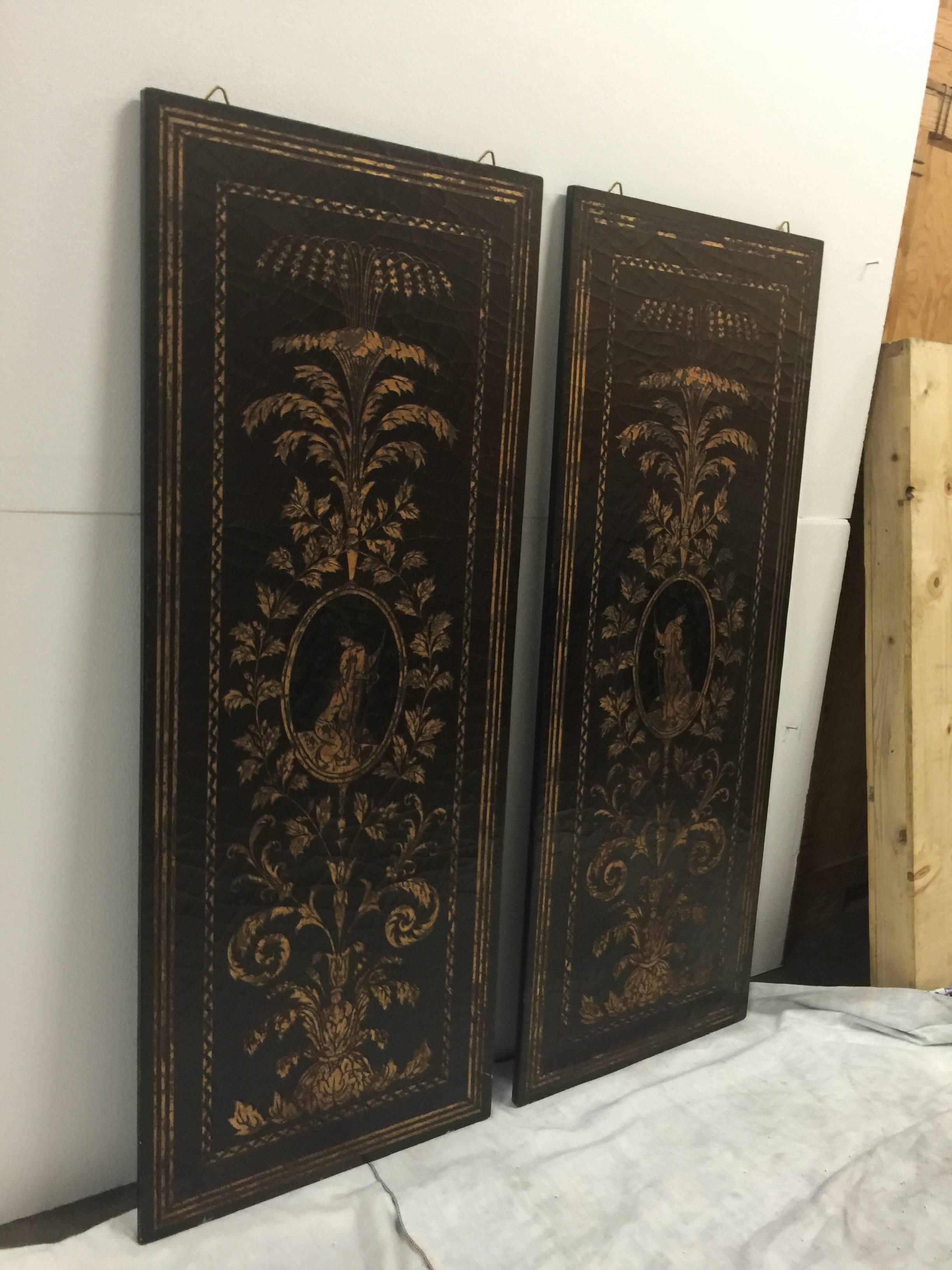 A pair of black lacquer and gilt wall screens. Italy, late 19th century, possibly earlier. Each screen features a flora motif and a center medallion with portrait of a period female. Designed to be used as wall decor but may be customized to be used