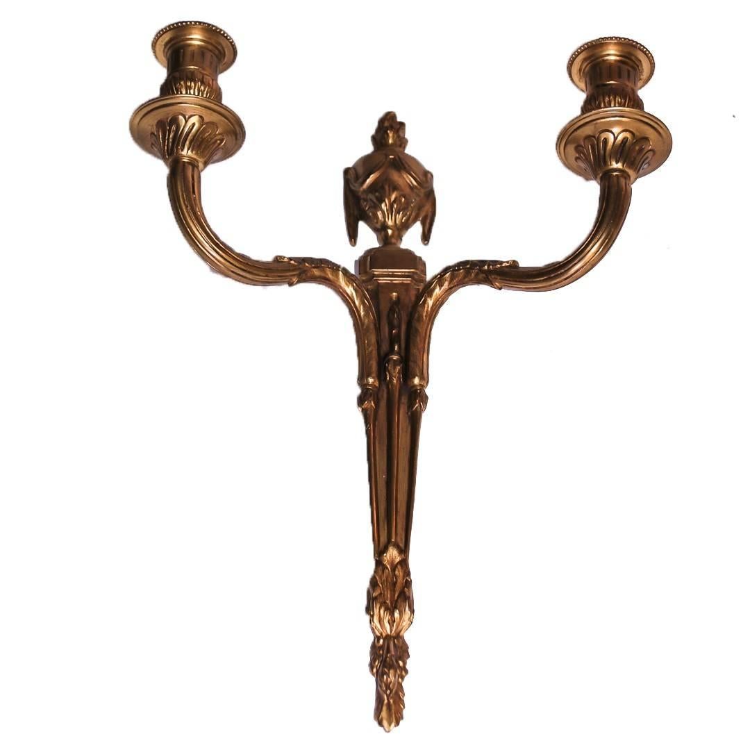 Pair of two-arm bronze wall-mounted candelabras in a classical style and featuring a laurel leaf design. France, circa 1940.
