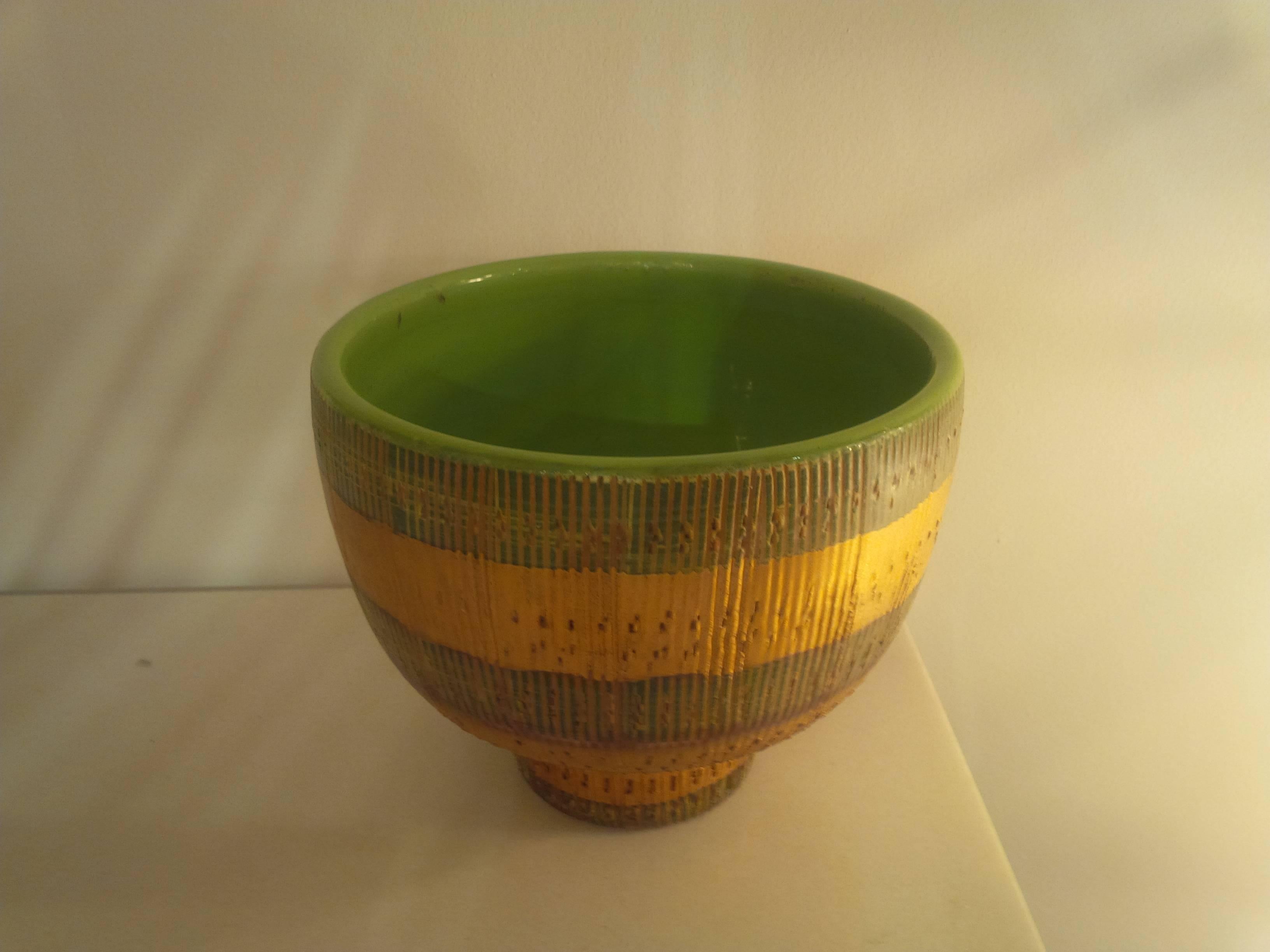 A handmade ceramic rooted bowl or planter by Rymor. Features a sgraffito textured surface with alternating bands of gold and pale green. Signed.