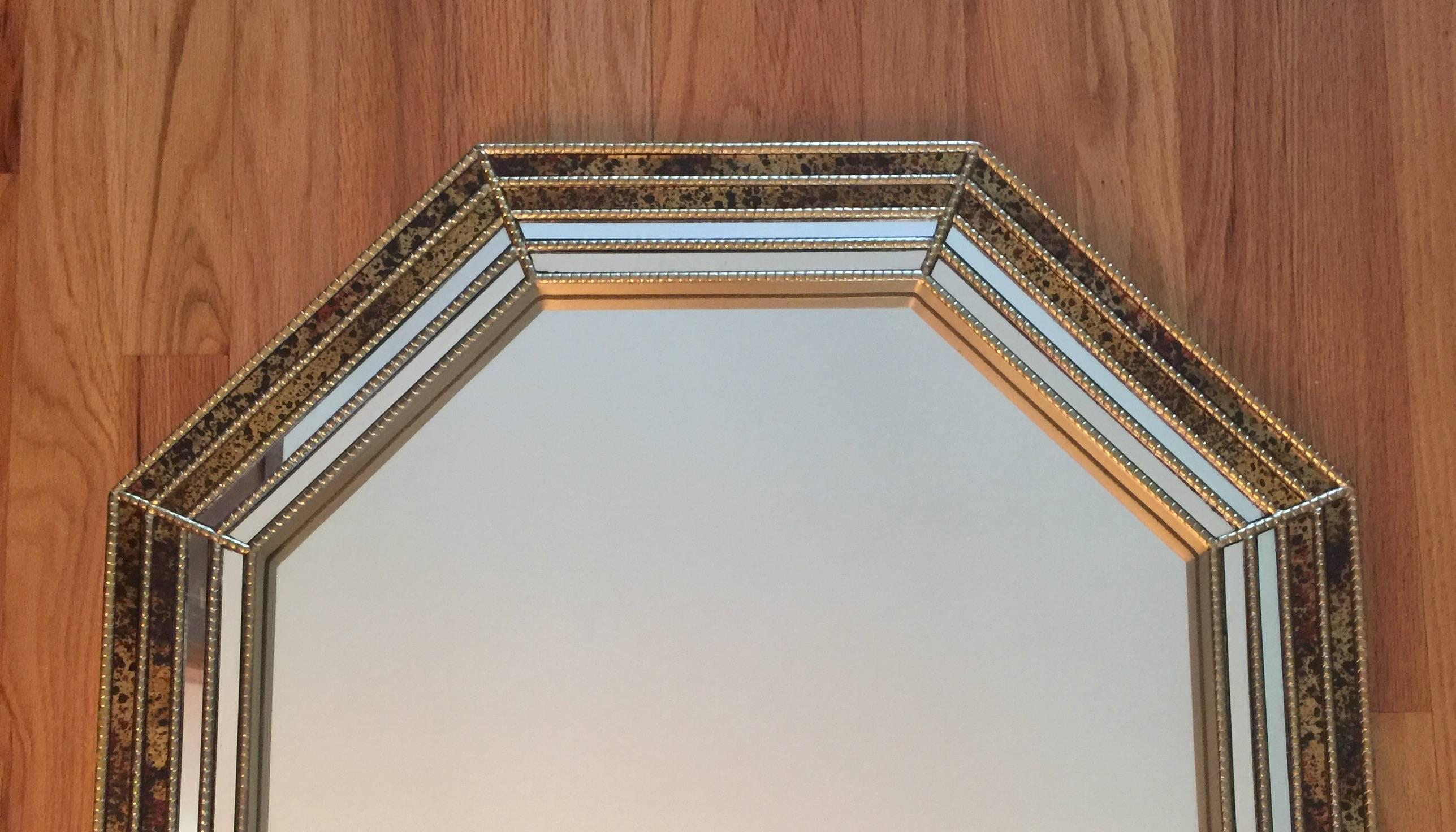 An octagonal-shaped wall mirror having a beaded brass frame with an oil drop inlaid decoration reminiscent of tortoiseshell. Made by LaBarge.  Circa 1970. A substantial and beautifully made mirror.  