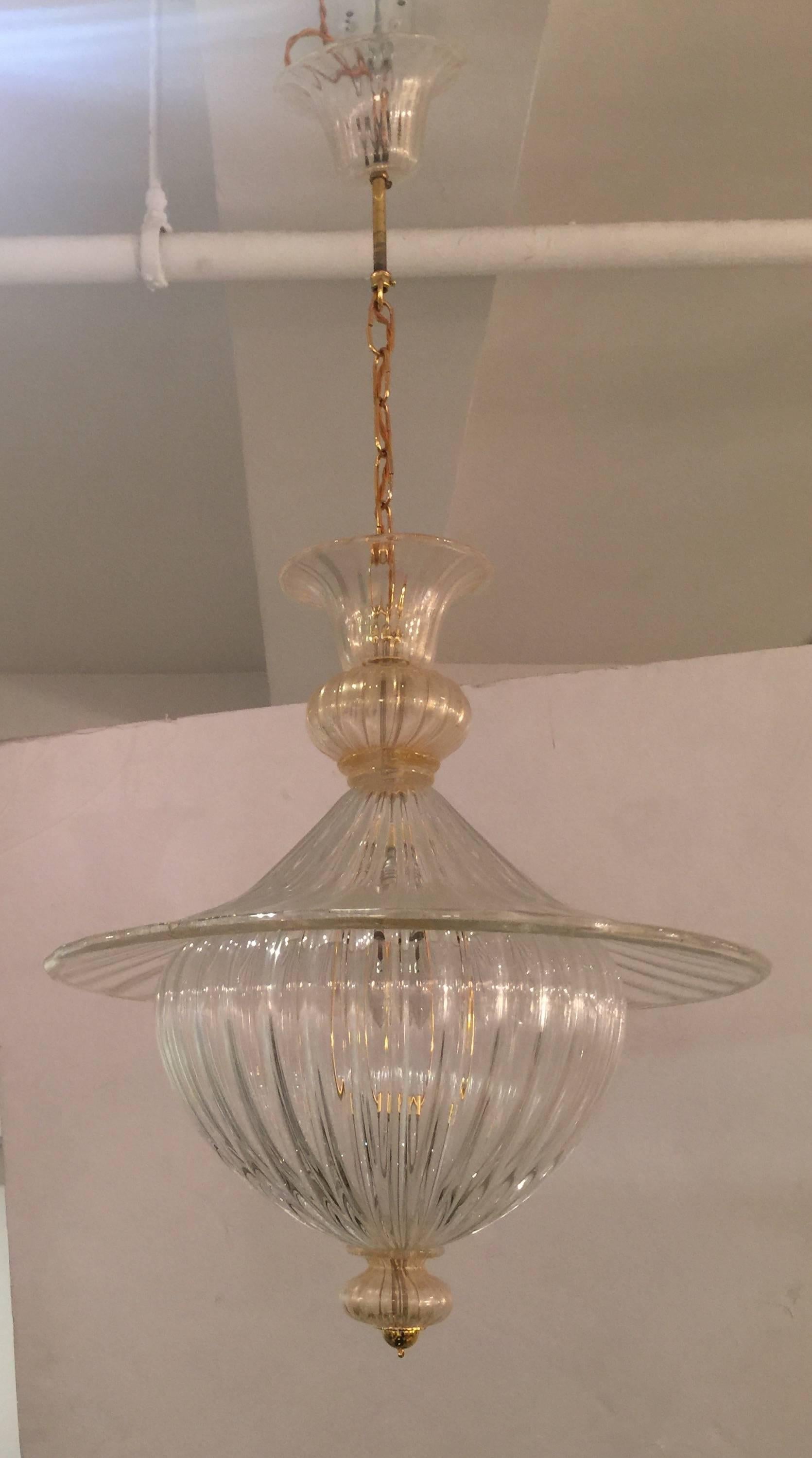 A Murano crystal and gilt multi-tier chandelier attributed to Seguso and reminiscent of designs by Gio Ponti, Italy, circa 1950. Electrified for U.S.

Features gilt metal accents and a matching canopy. Drop height may be slightly adjusted by