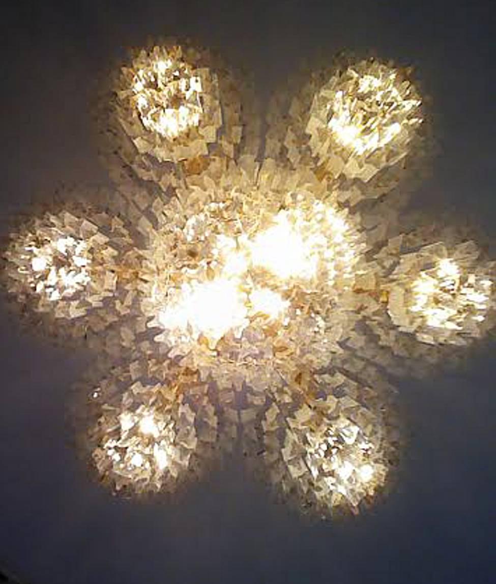 A monumental three-tier chandelier made of Lucite pendants, Italy, circa 1960. 

Uses 14 standard socket U.S. bulbs; shown with 40 watt bulbs; takes up to 100 watts. 

Dimensions: 44 inches in diameter by 48 inches tall (not including hanging