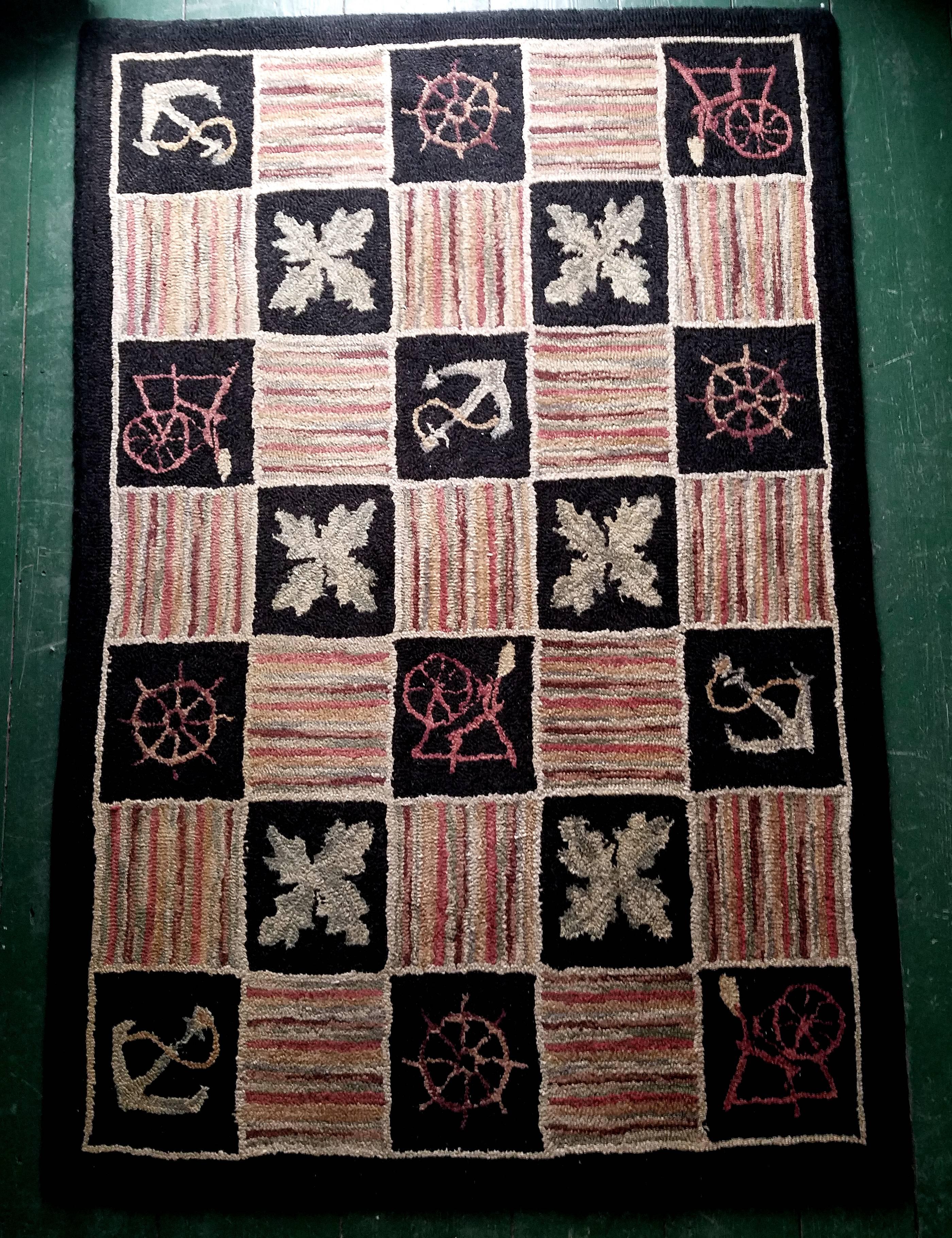 This spectacular vintage American, most likely Maine, hooked rug is extremely visual with a stunning myriad of colors contained within a striped border with spinning wheel and nautical patterned weaves. These squares are outlined in a thin border of