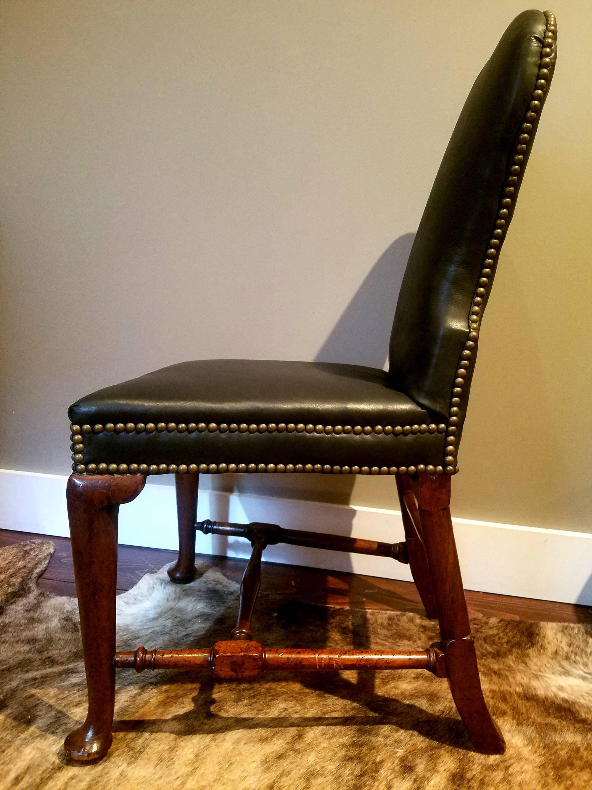 Beautiful and comfortable, this walnut upholstered chair with cabriole legs, yoked crestrail and delicate block and turned stretchers is 18th century elegance with a timeless modernity. 
Provenance: Purchased from an East Hampton Estate.