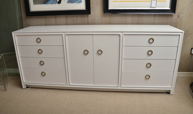 Attractive Mid-Century white lacquer eight-drawer dresser with two central cabinets. Inside the cabinet and three additional drawers. The drawers have unusual ring pulls.