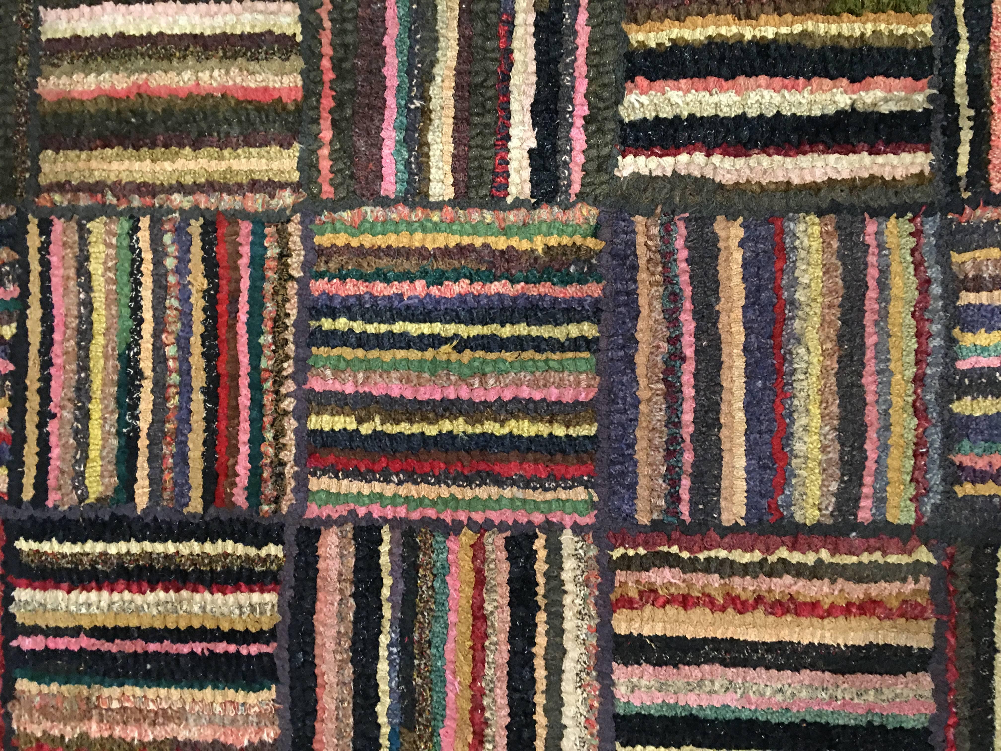 Striped block pattern hooked rug. Recently cleaned a couple of small repairs on the back. Good strong condition.