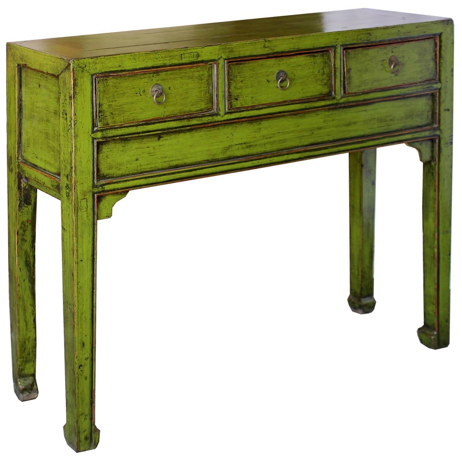 Lime green console table with three drawers, straight skirt and horse hoof-style feet. Use in an entry way or behind a sofa for a pop of color in a contemporary interior.