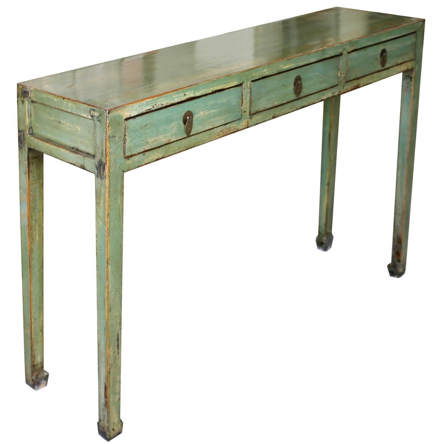 Contemporary three-drawer green lacquer console table can be placed behind a sofa or in an entry way.
